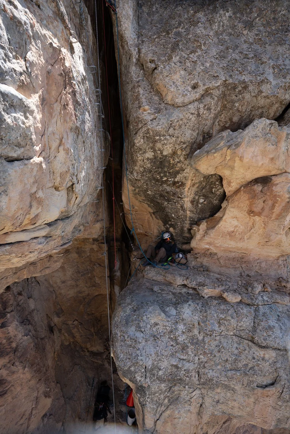 Climber moving through the narrow Womb Fight chimney on Jur-Ass-Kicked. Confined chimney climbing on the Womb Fight route variation.