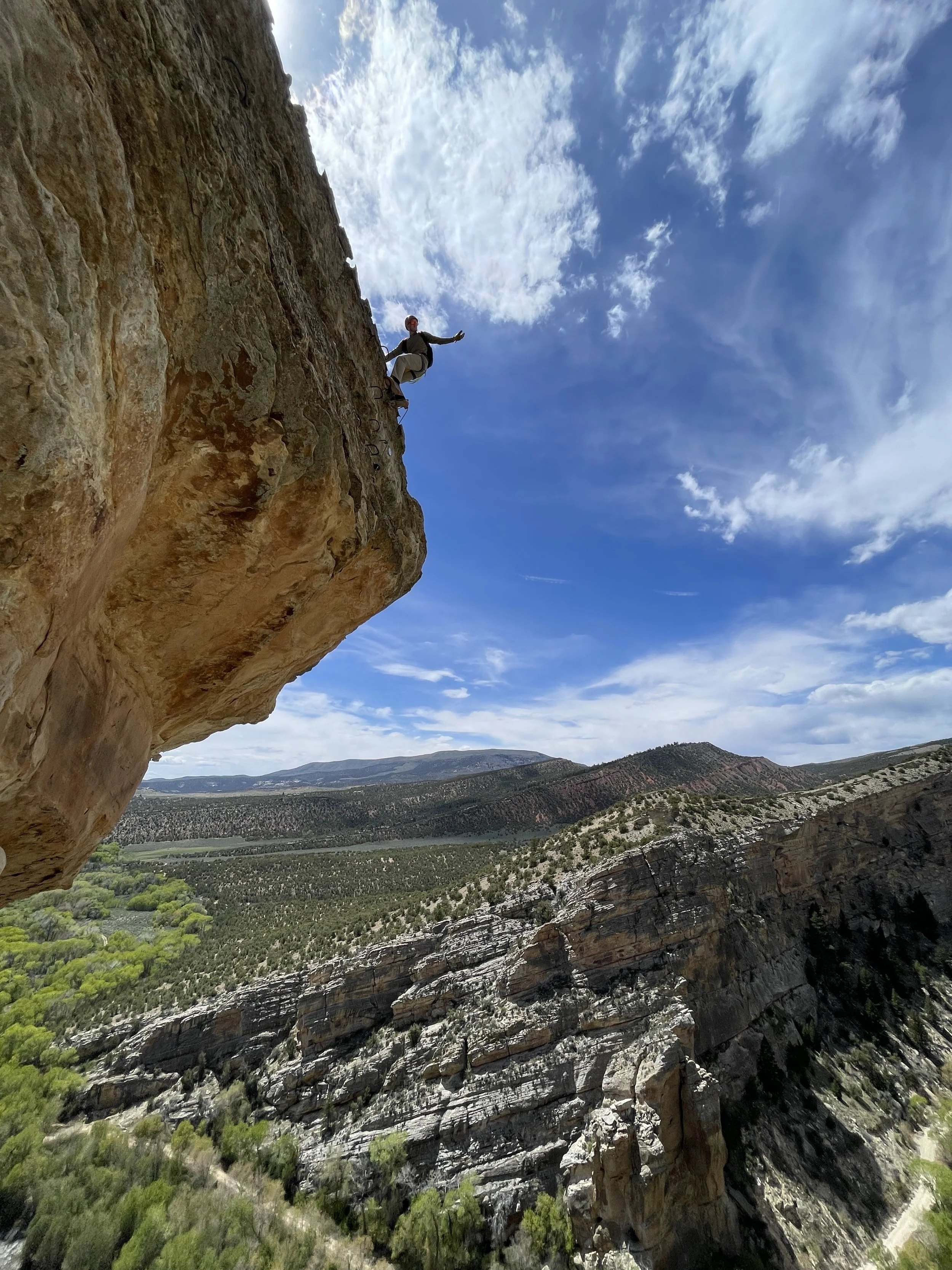 Climber ascending the exposed Abduction exit from Ashley Gorge.