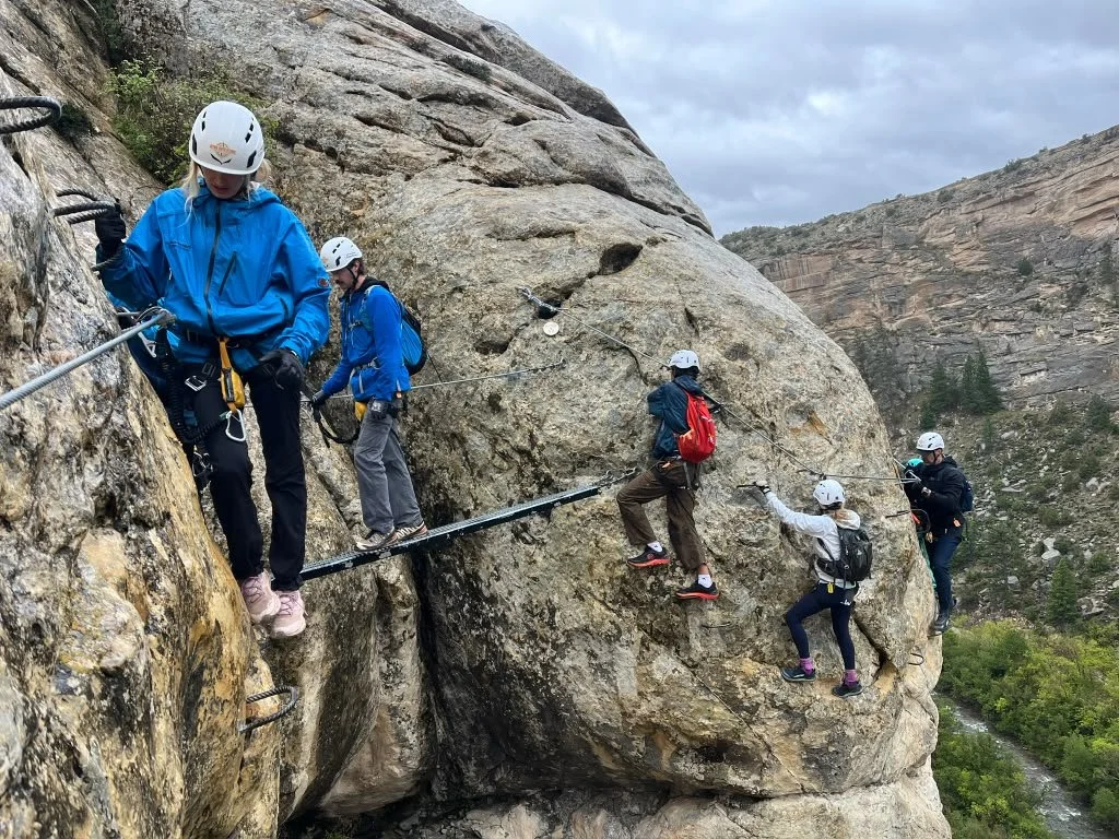 Climber traversing the sandstone wall of The Soup sector in Ashley Gorge.