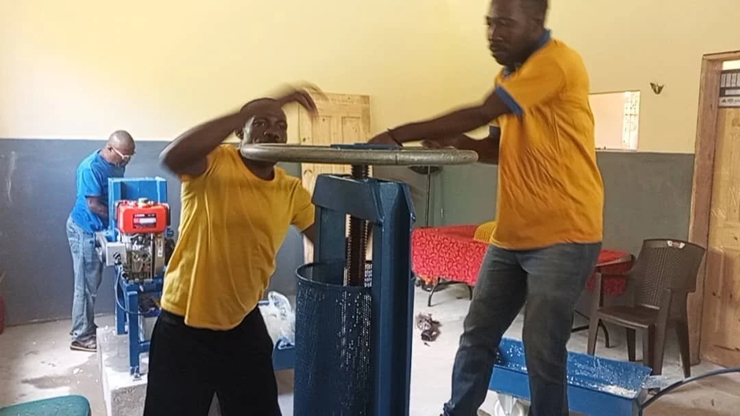 Cassava-Pressing flour down to feed into smaller packets.JPG