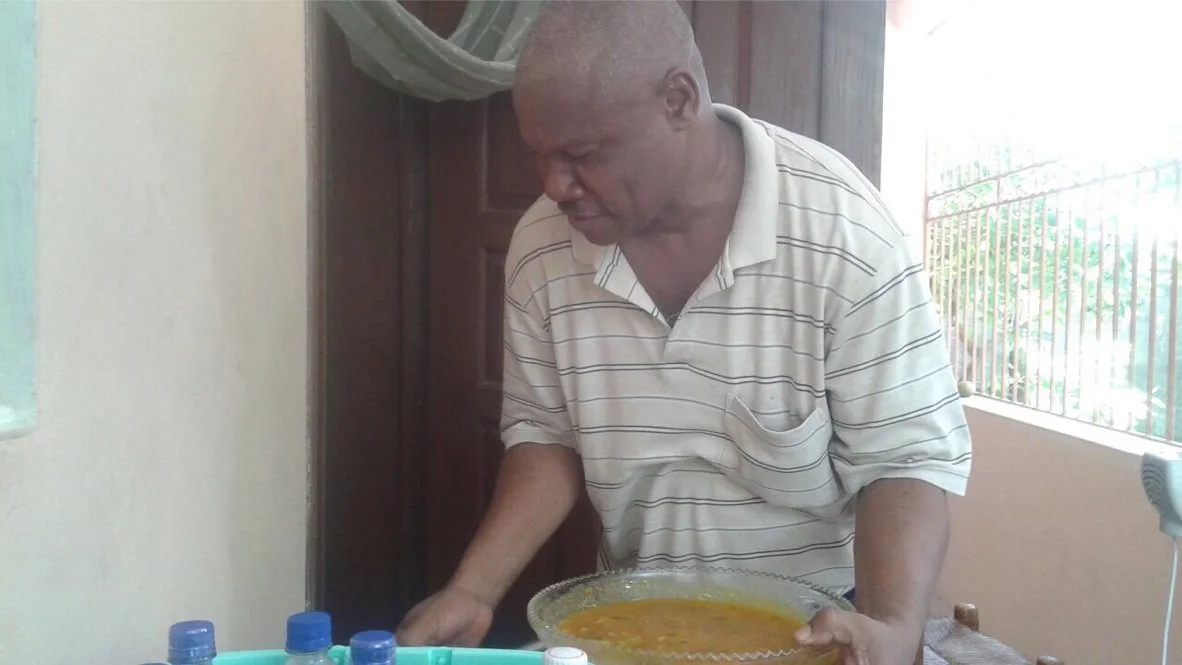 Eloi serving lunch to APSHA team in Leogane