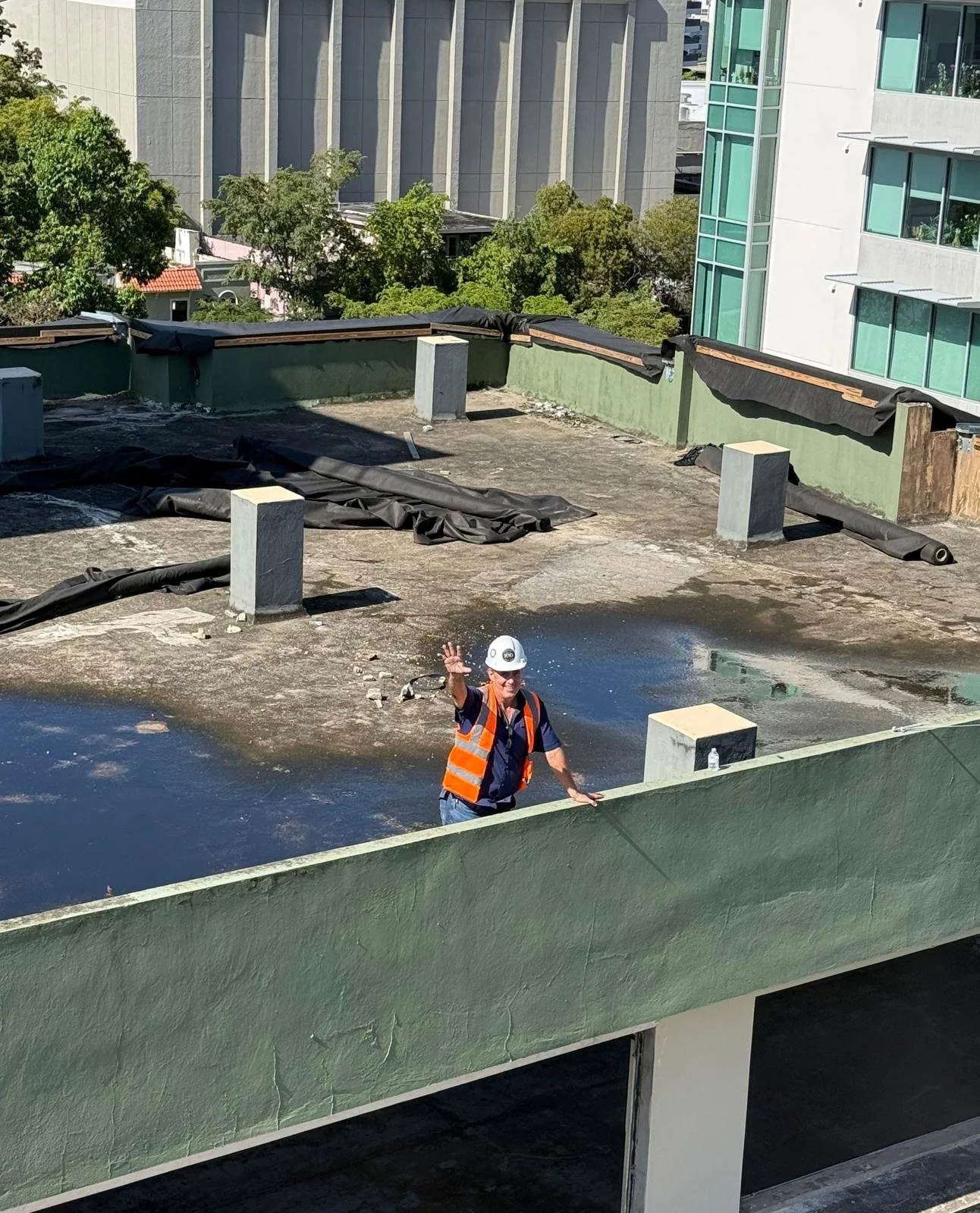 Group of people wearing high-visibility vests standing in front of collapsed building debris.