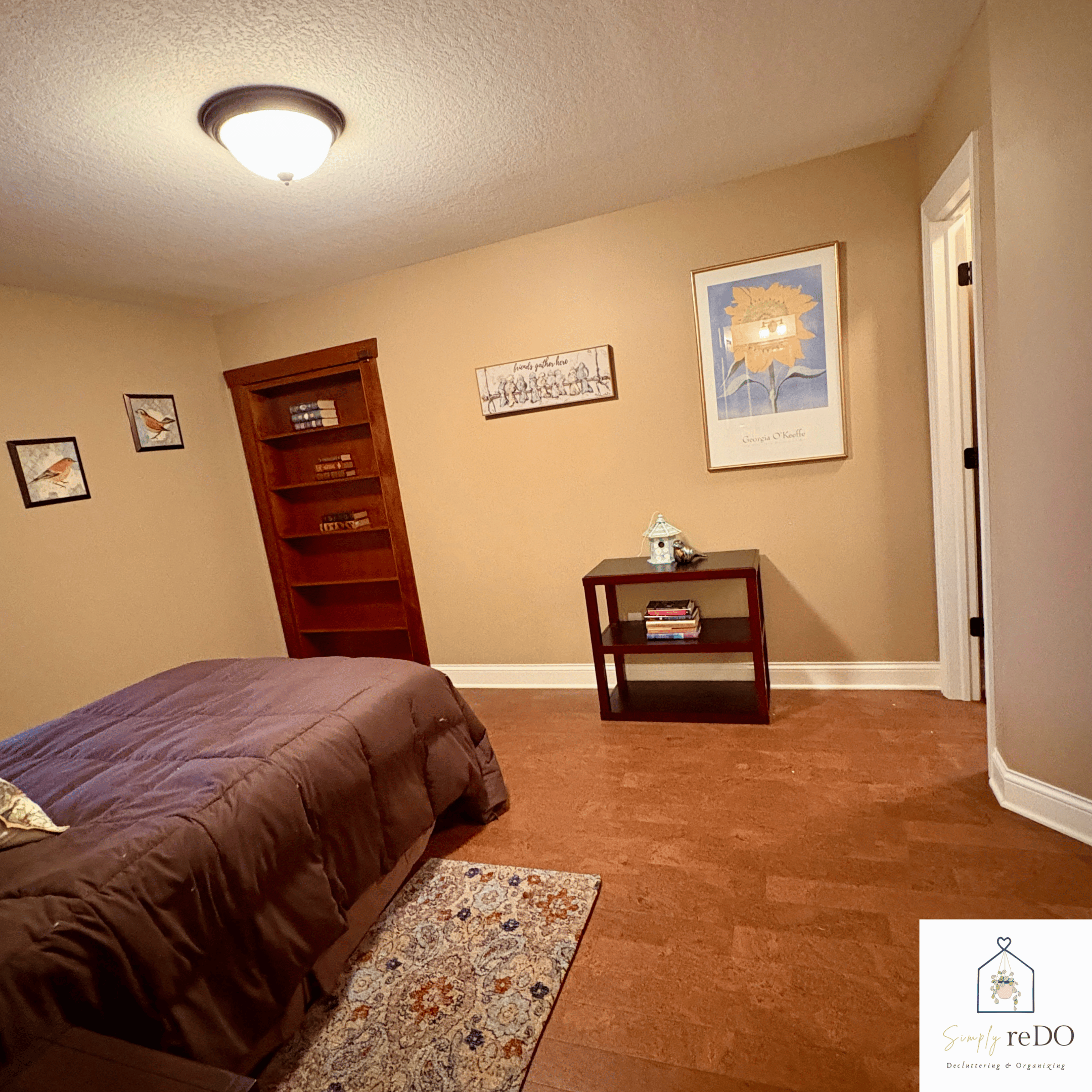 Guest bedroom after organization, angled view from the bathroom doorway with a finished, cohesive feel.