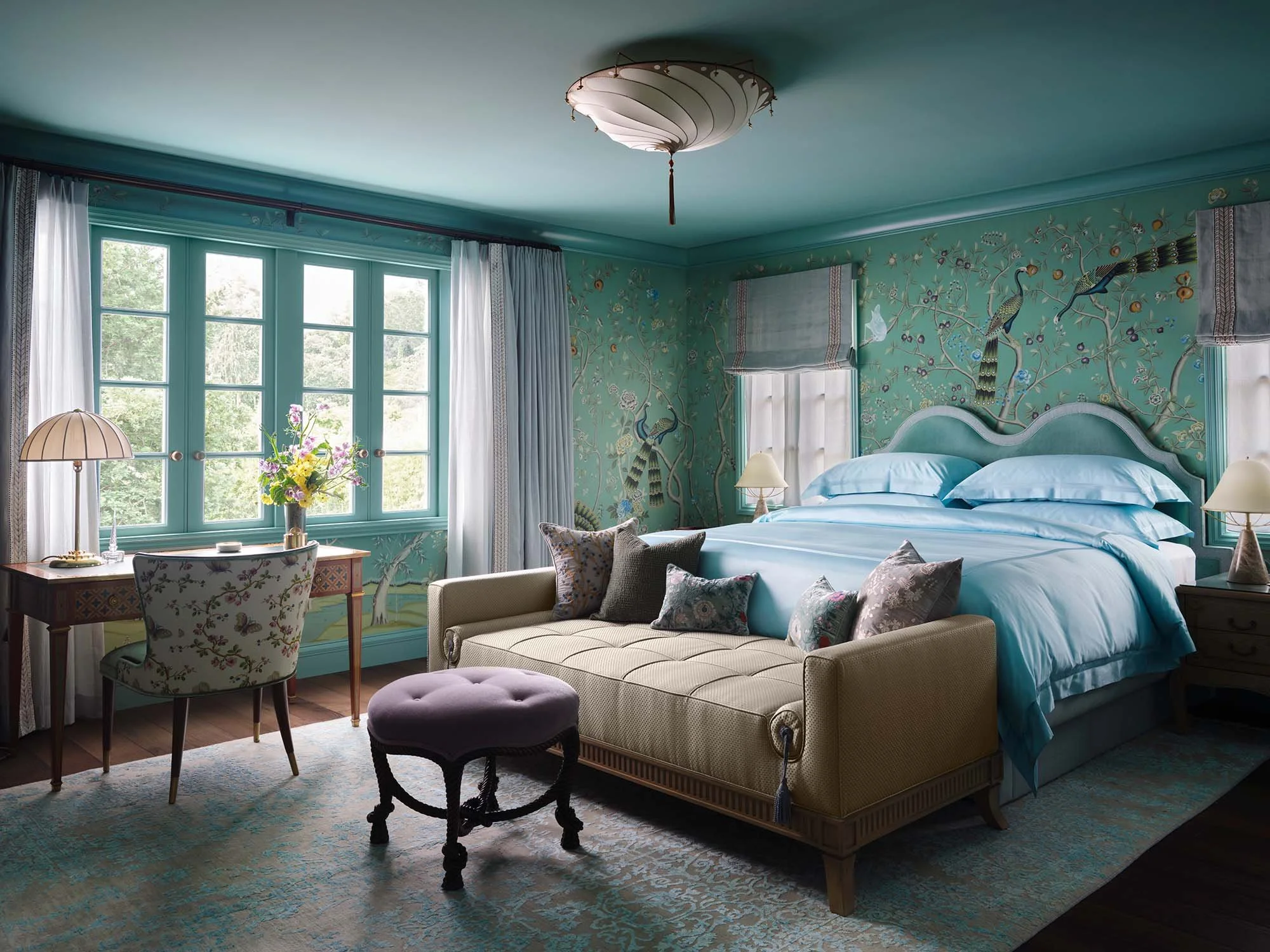 Teal custom casement windows in primary bedroom with chinoiserie peacock wallpaper and blue bedding.
