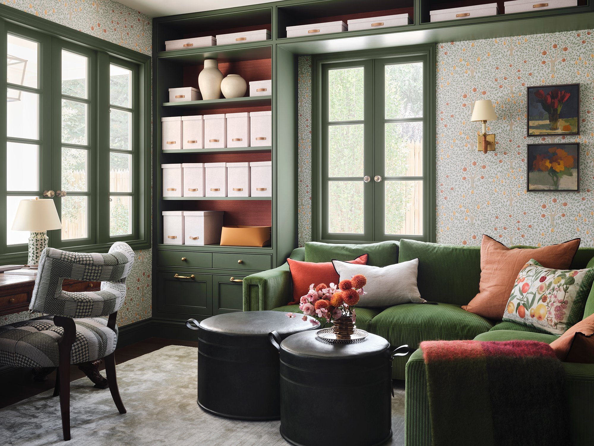 Forest green custom casement windows flanking built-in shelving in botanical wallpaper sitting room.