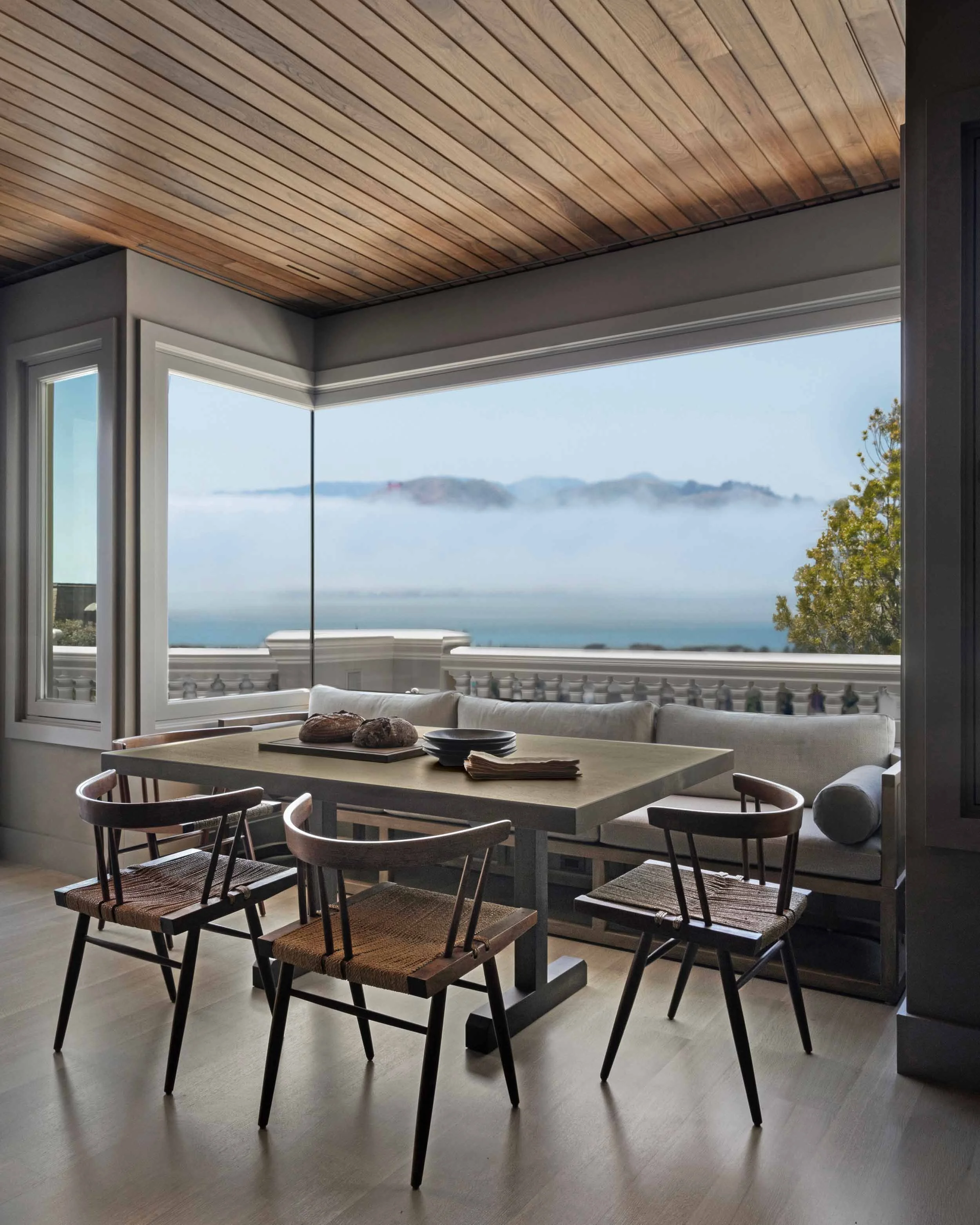Corner breakfast nook with built-in bench seating and dining table overlooking San Francisco Bay