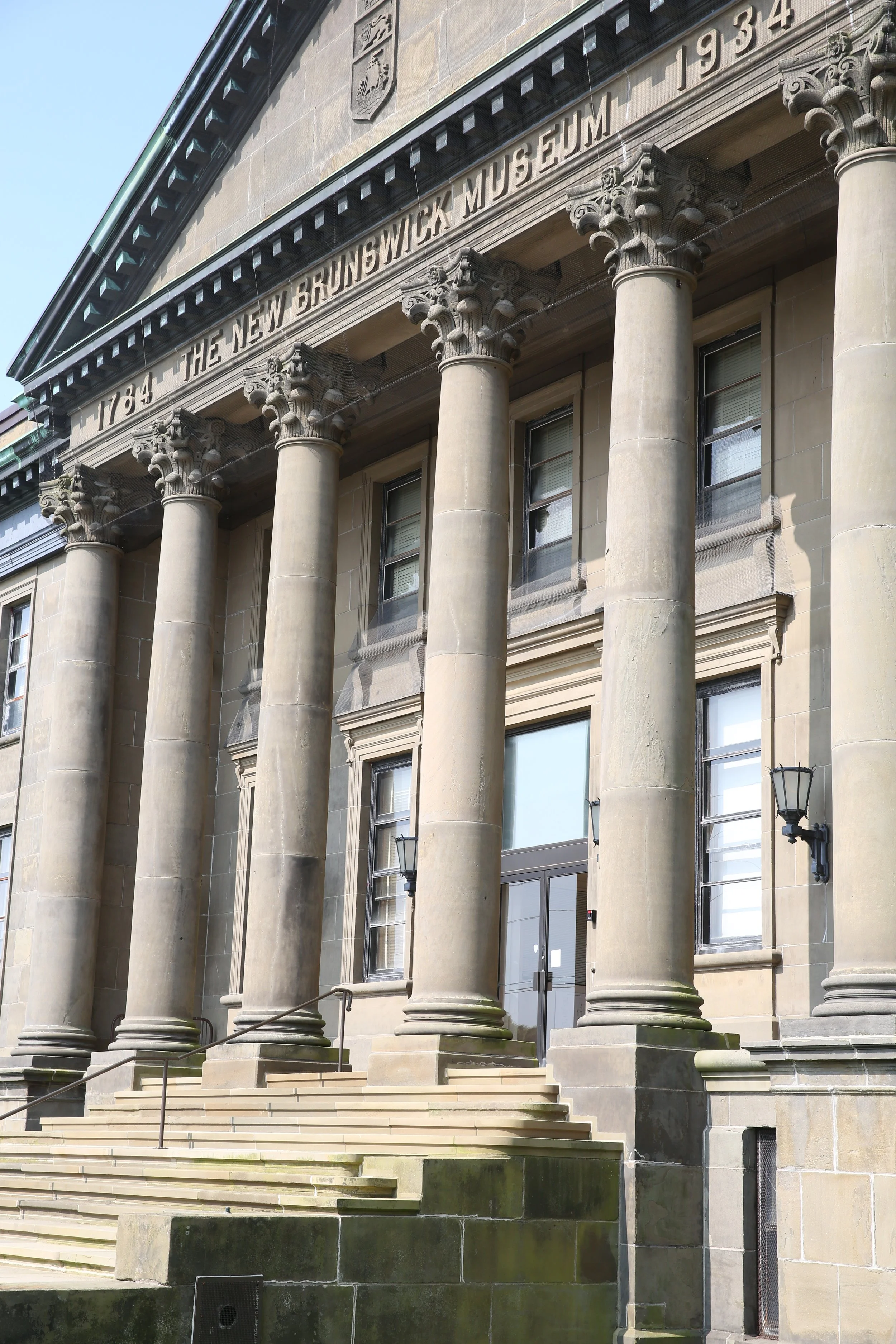 Front view of the New Brunswick Museum building with large columns and the inscription '1784 The New Brunswick Museum 1934' at the top.