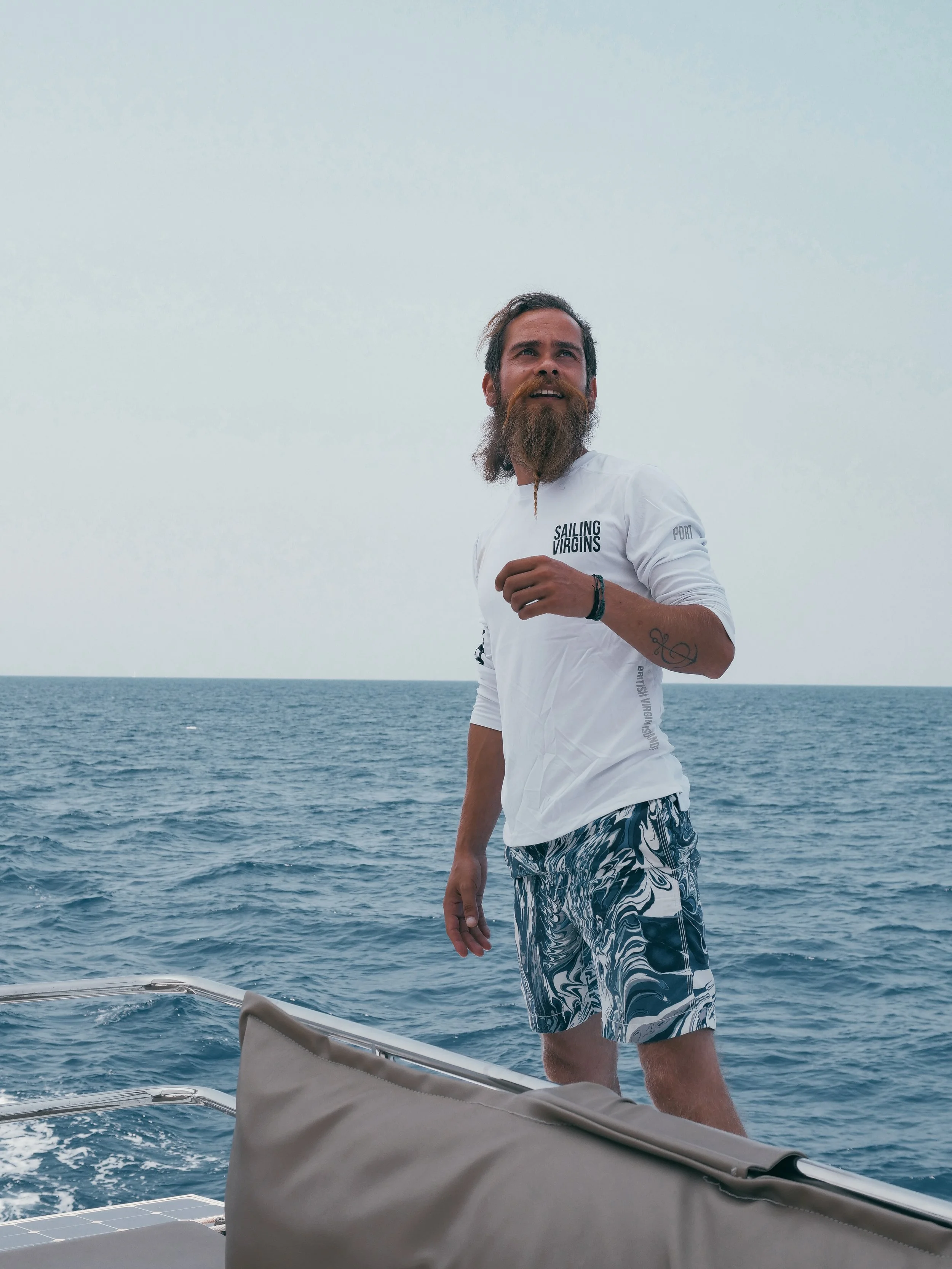 Male crew looking at sail on sailboat.jpg
