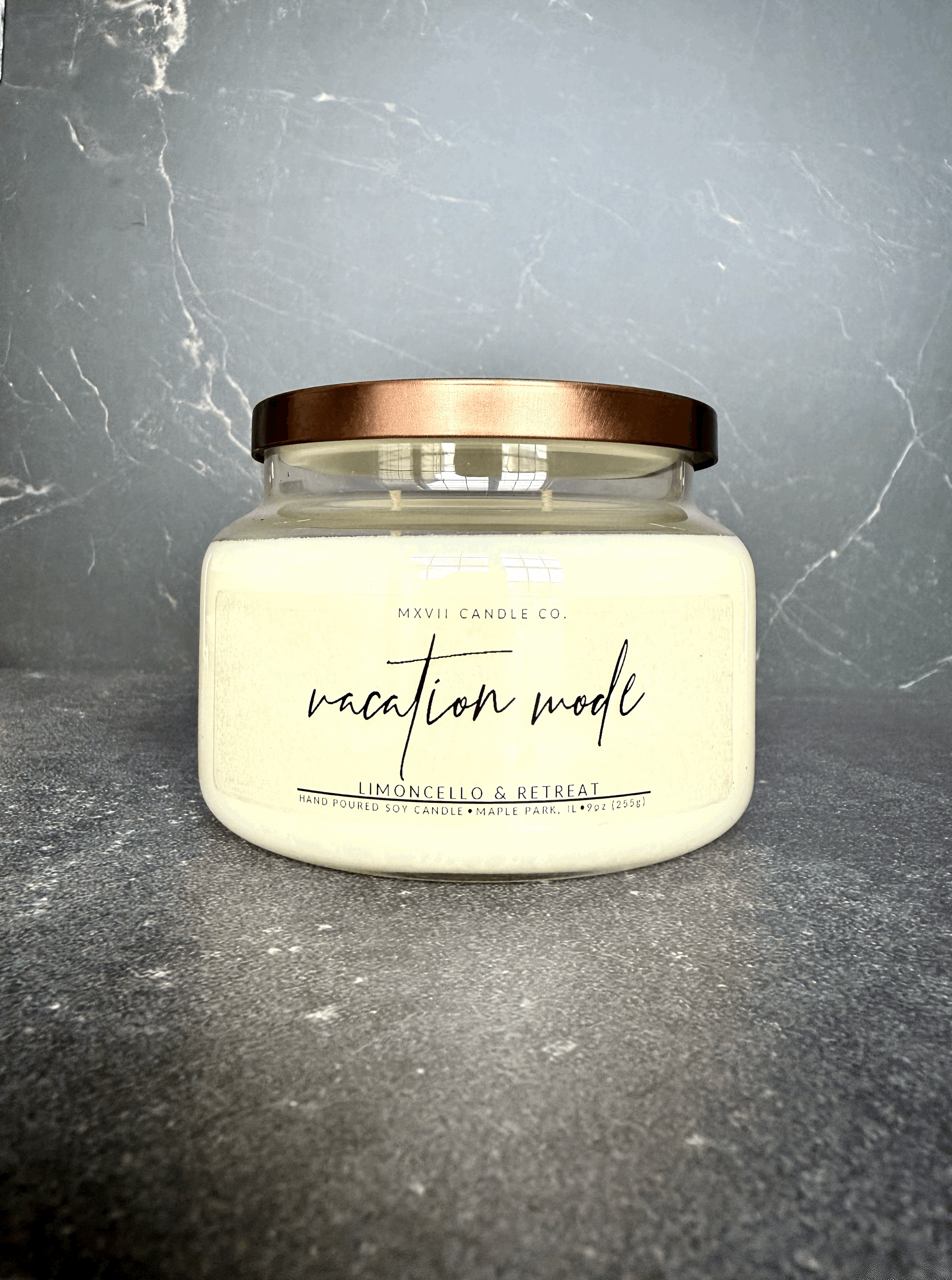 Limoncello soy candle in a clear jar with copper lid on black marble background — Vacation Mode by MXVII Candle Co.