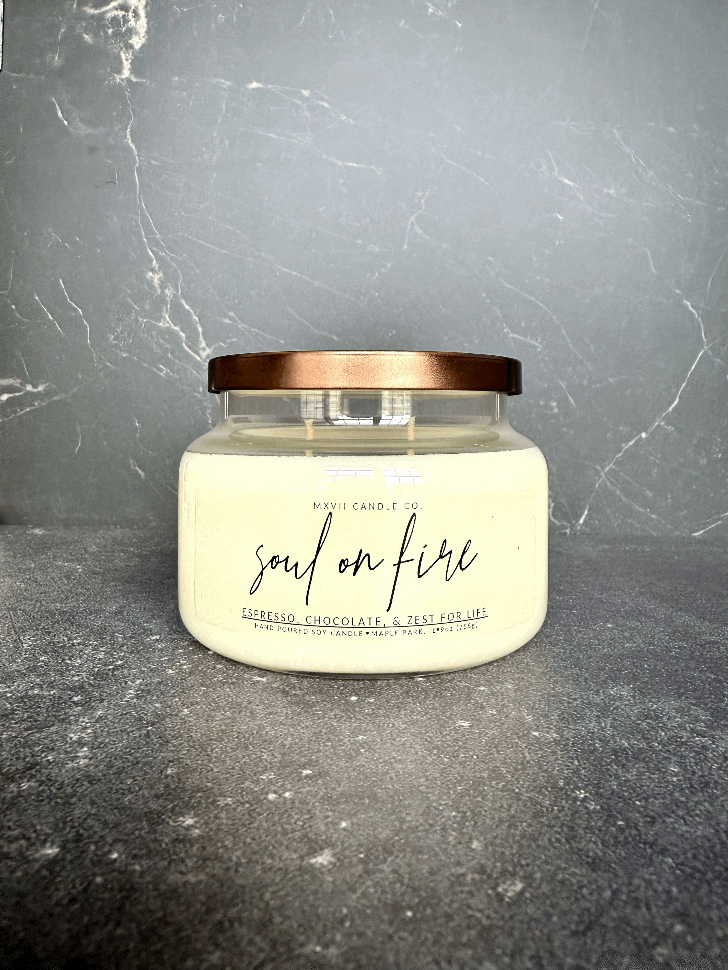 Chocolate Espresso soy candle in a clear jar with copper lid on black marble background — Soul on Fire by MXVII Candle Co.