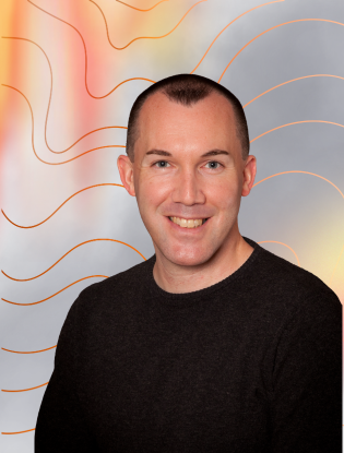 Michael standing in front of a colorful abstract background with orange and red lines.