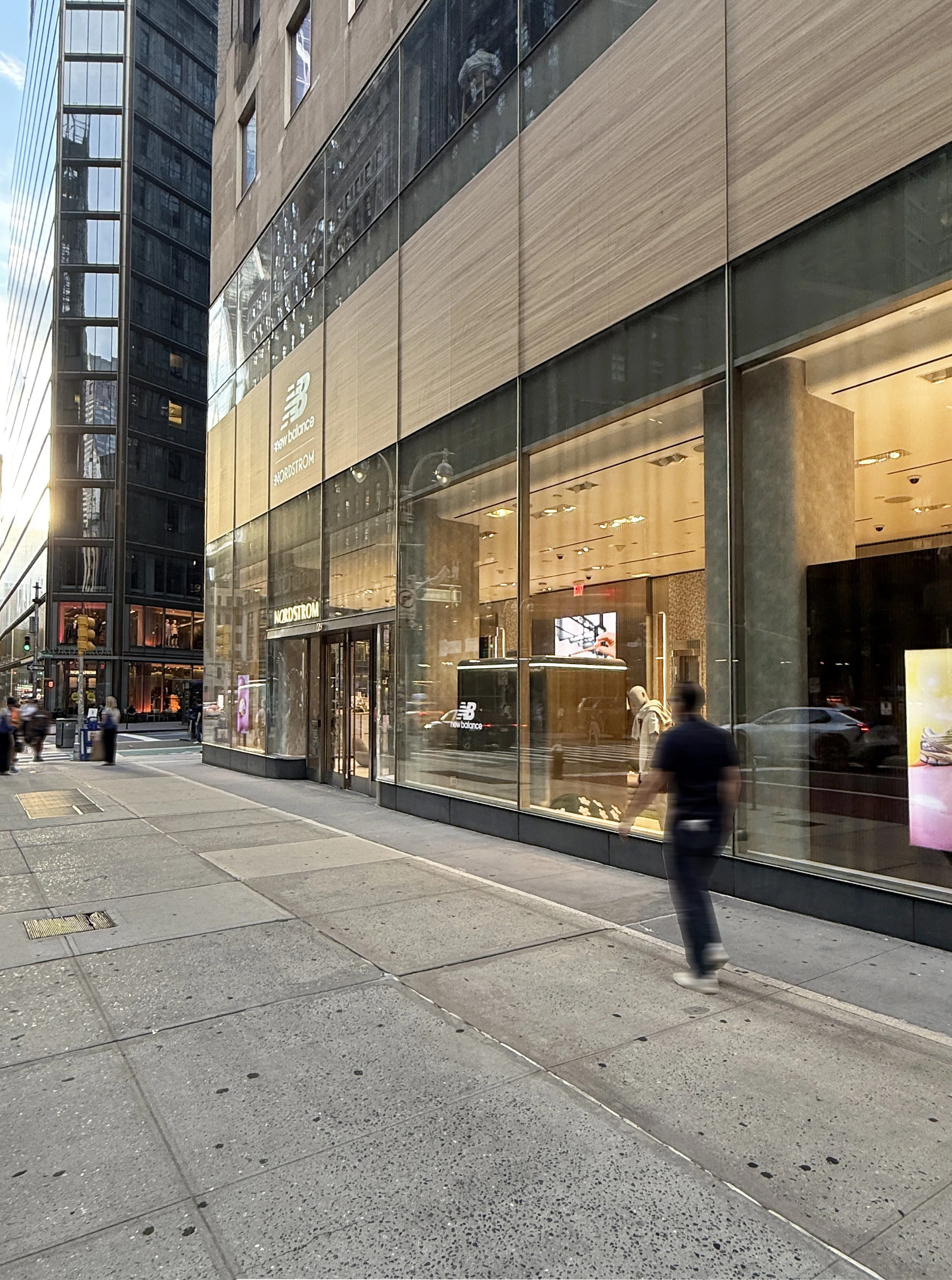 Night view of Nordstrom store exterior on a busy New York City street with pedestrians.