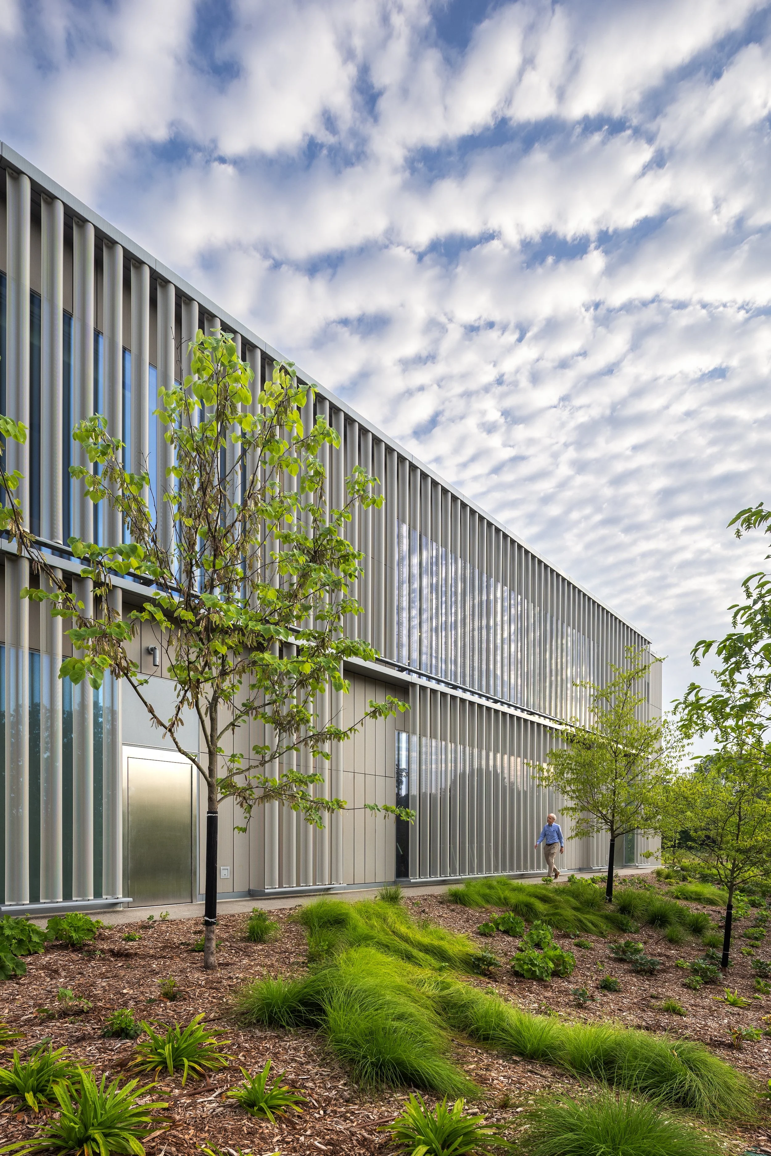 Glass sides of building reflecting the movement of the clouds