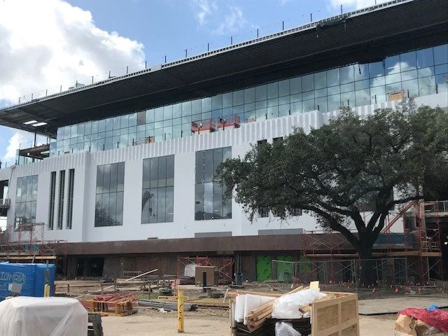 In progress construction shot of the north side of the building with new windows punched into the concrete