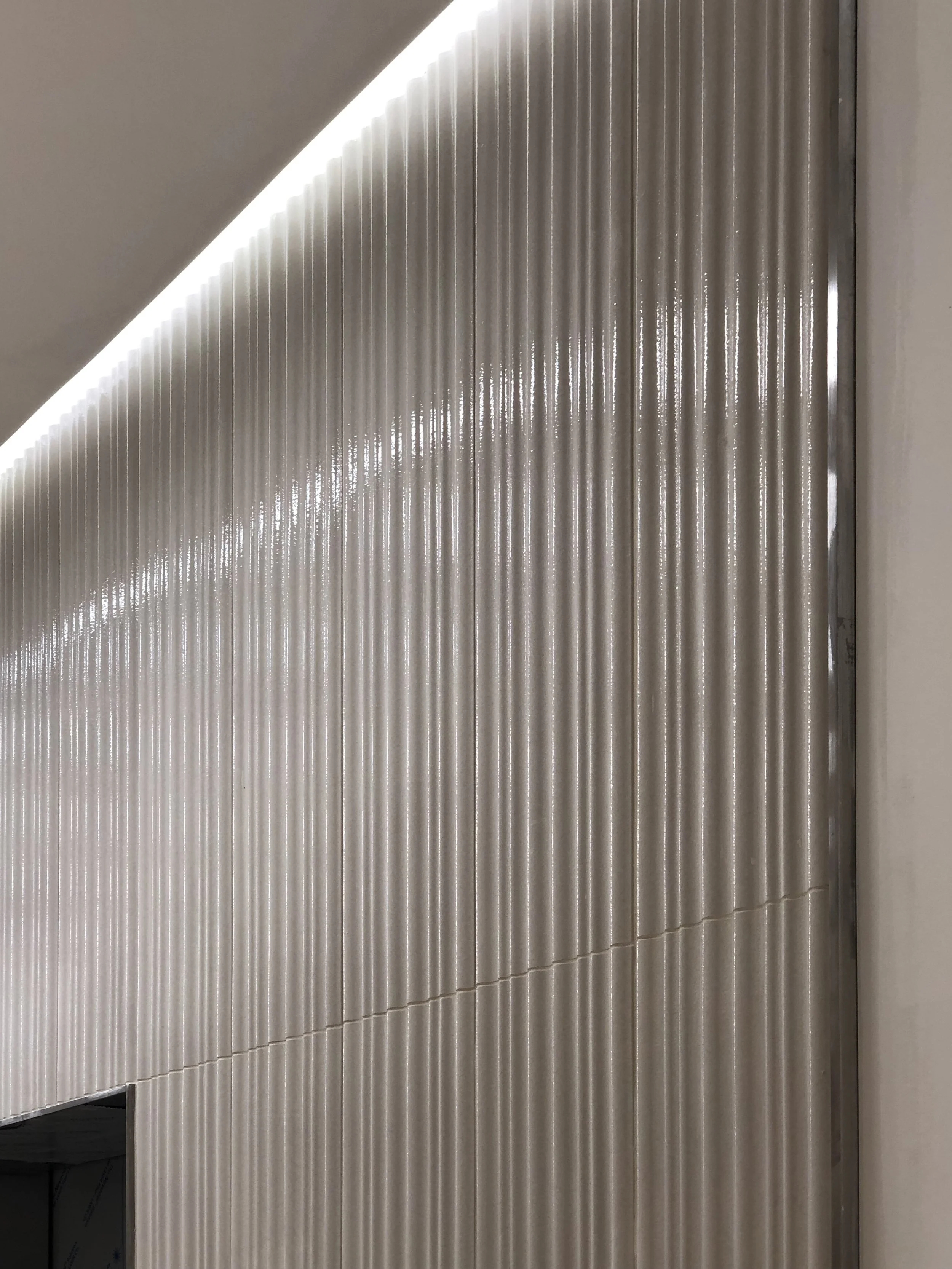 View of terracotta wall on elevator wall that gets light to move vertically