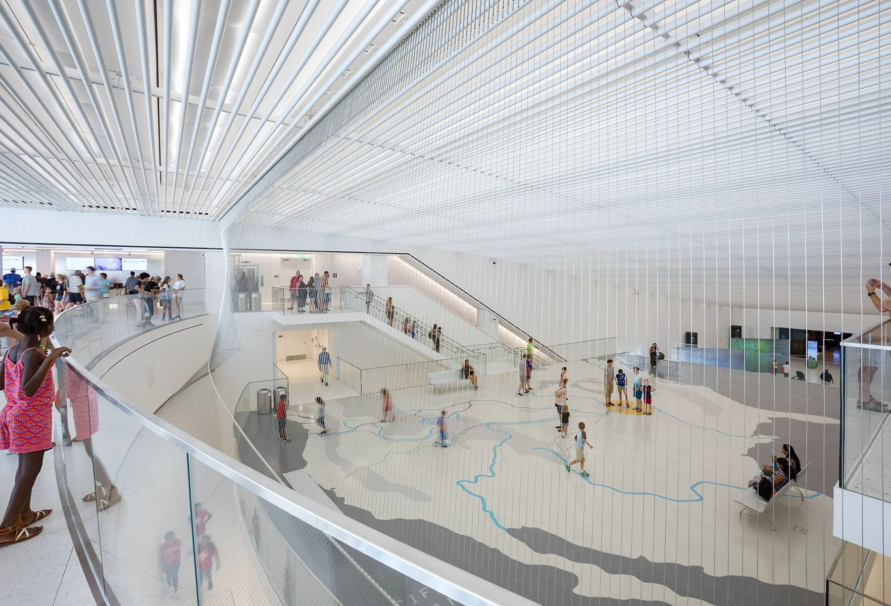 entry railing that overlooks the level below and shows path through the museum, map painted on ground