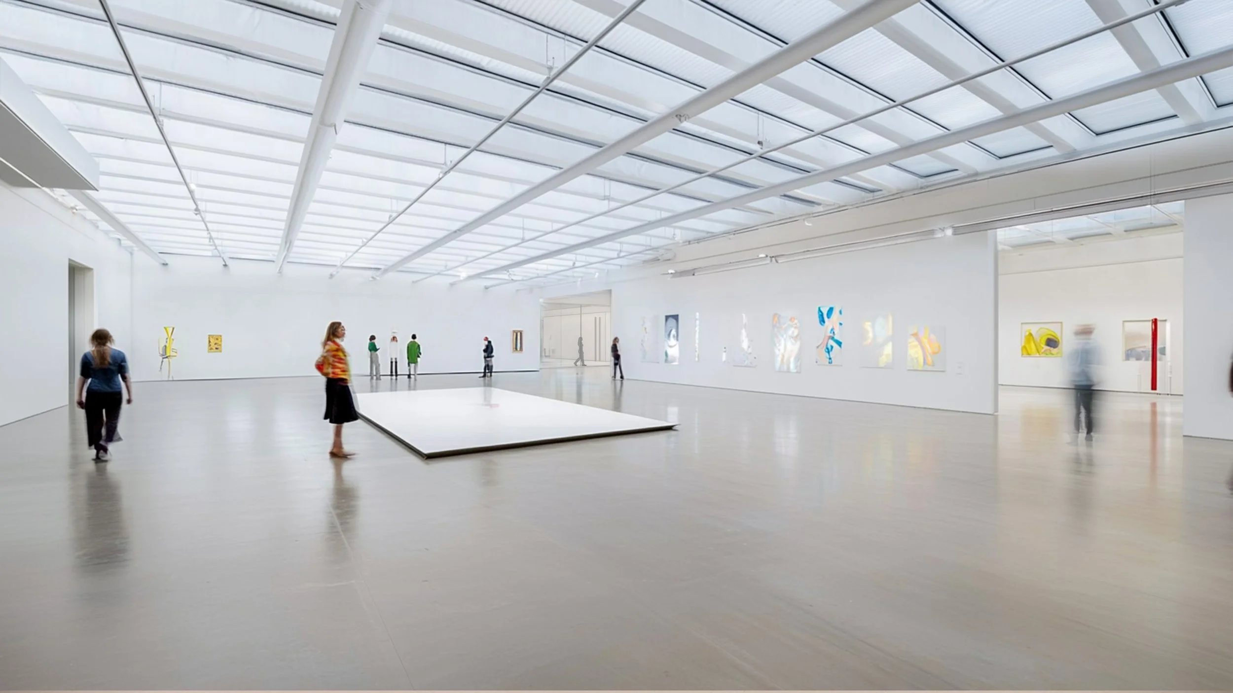 Bright, spacious contemporary art gallery with white walls, high skylit ceilings, and minimalist artwork displayed around the room.