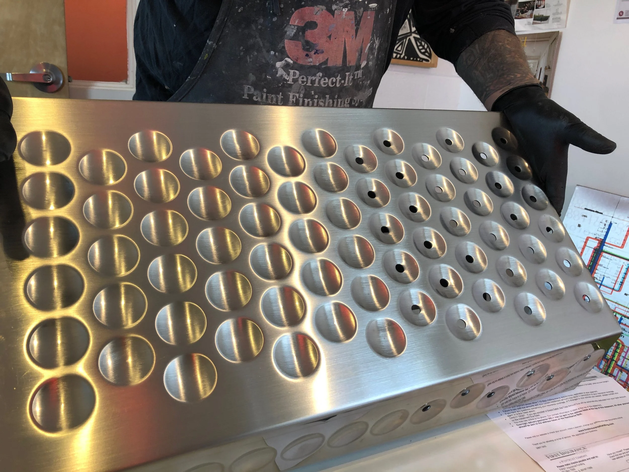 Embossed and selectively perforated stainless steel panel fabricated by Artform 