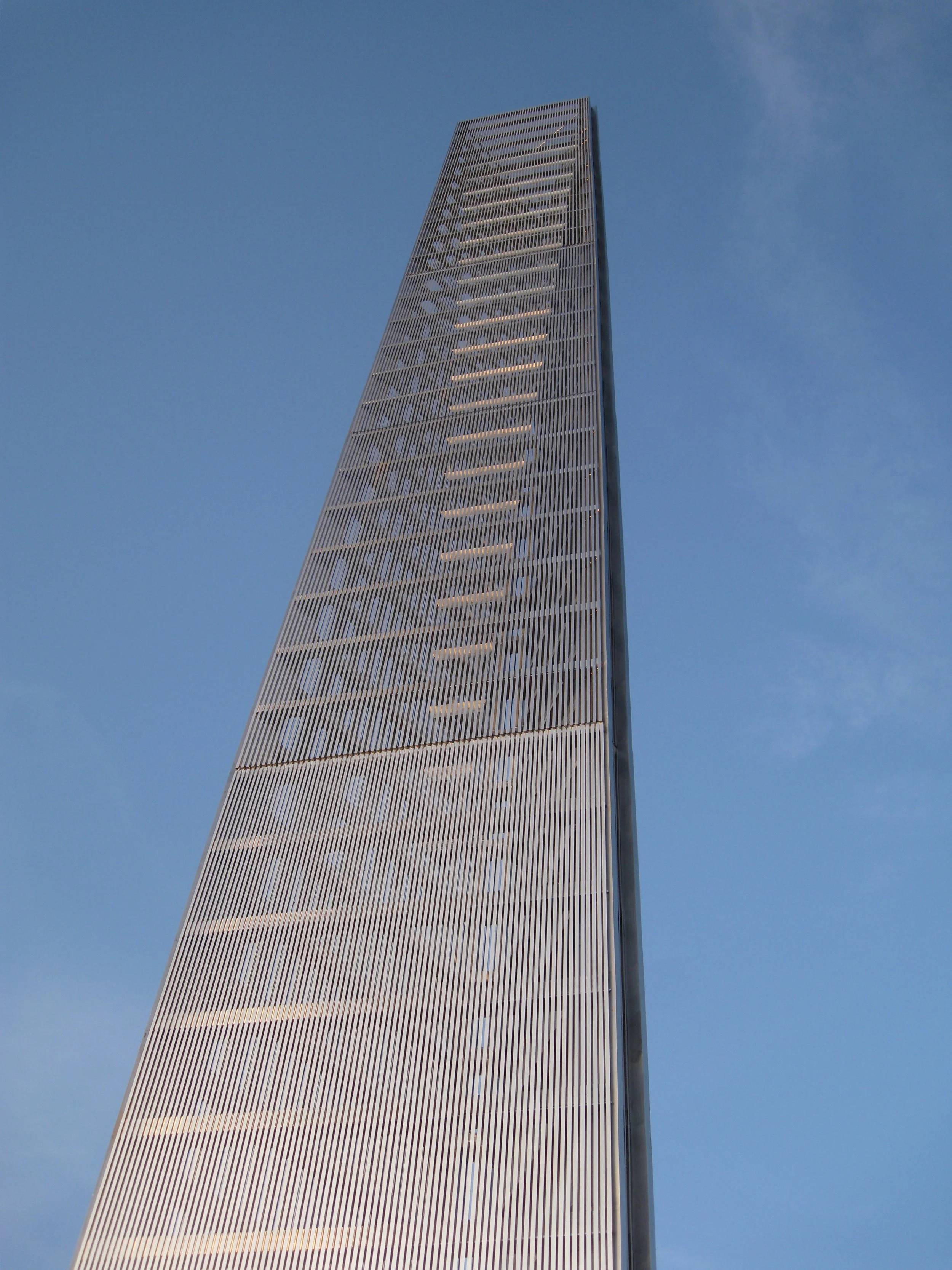 Close-up of the Prismatic Light Pillar showing rippling wave-patterned surface detail against a blue sky.
