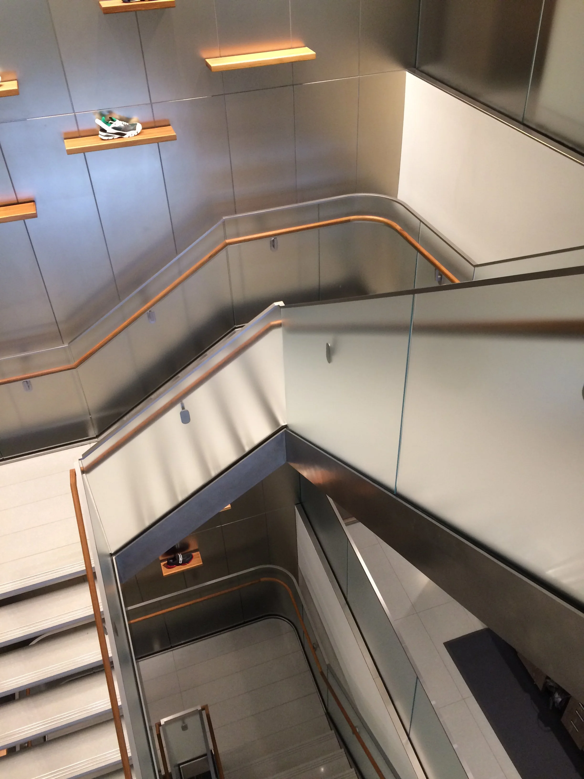 Connecting staircase looking down two levels with display surfaces
