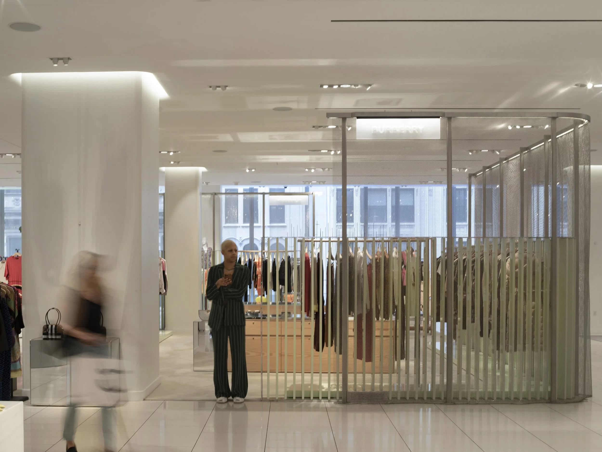 Lighting around structural columns with mesh dividers around retail vendor shops