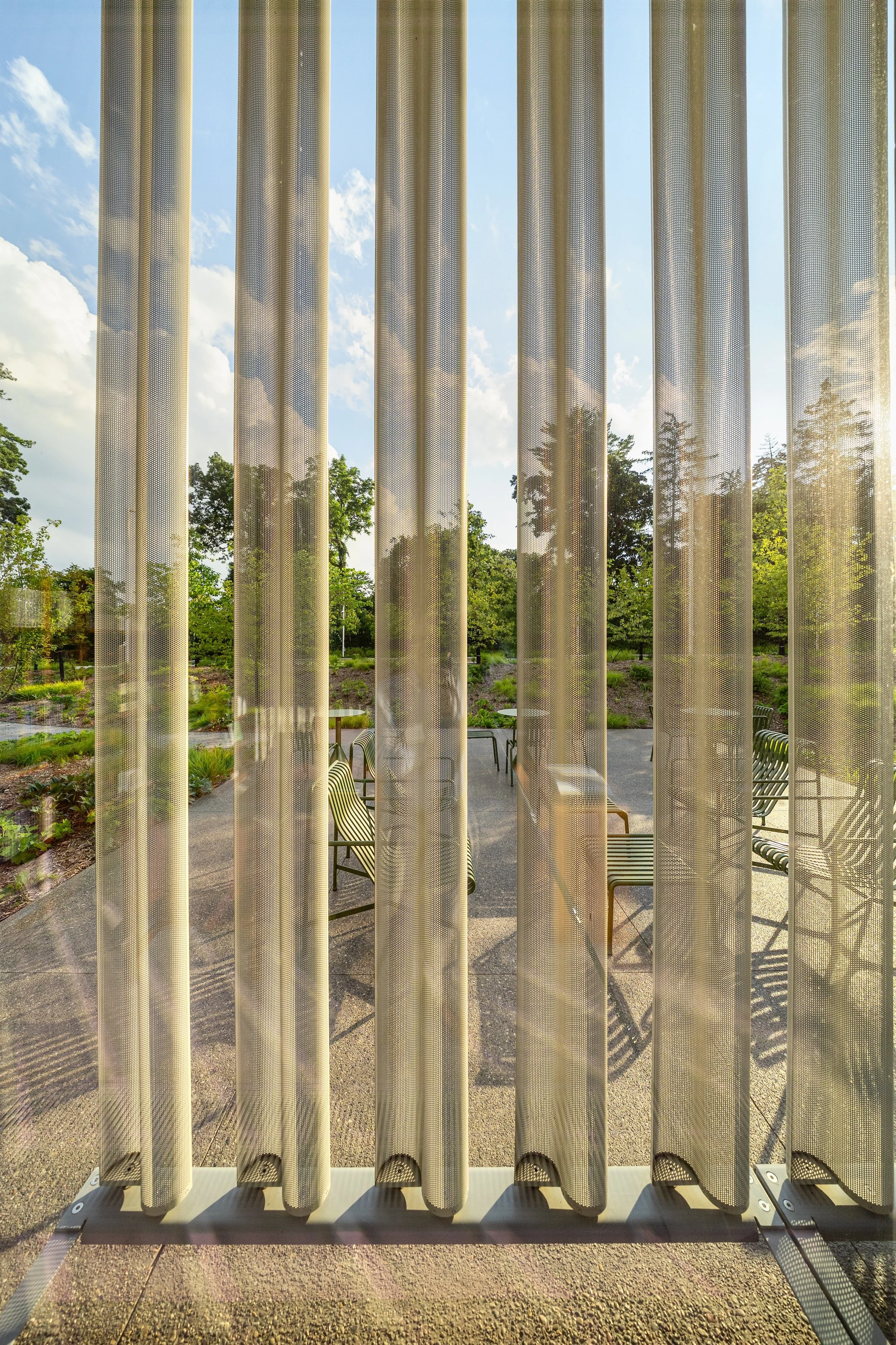 View through solar protection screens from interior to courtyard with seating