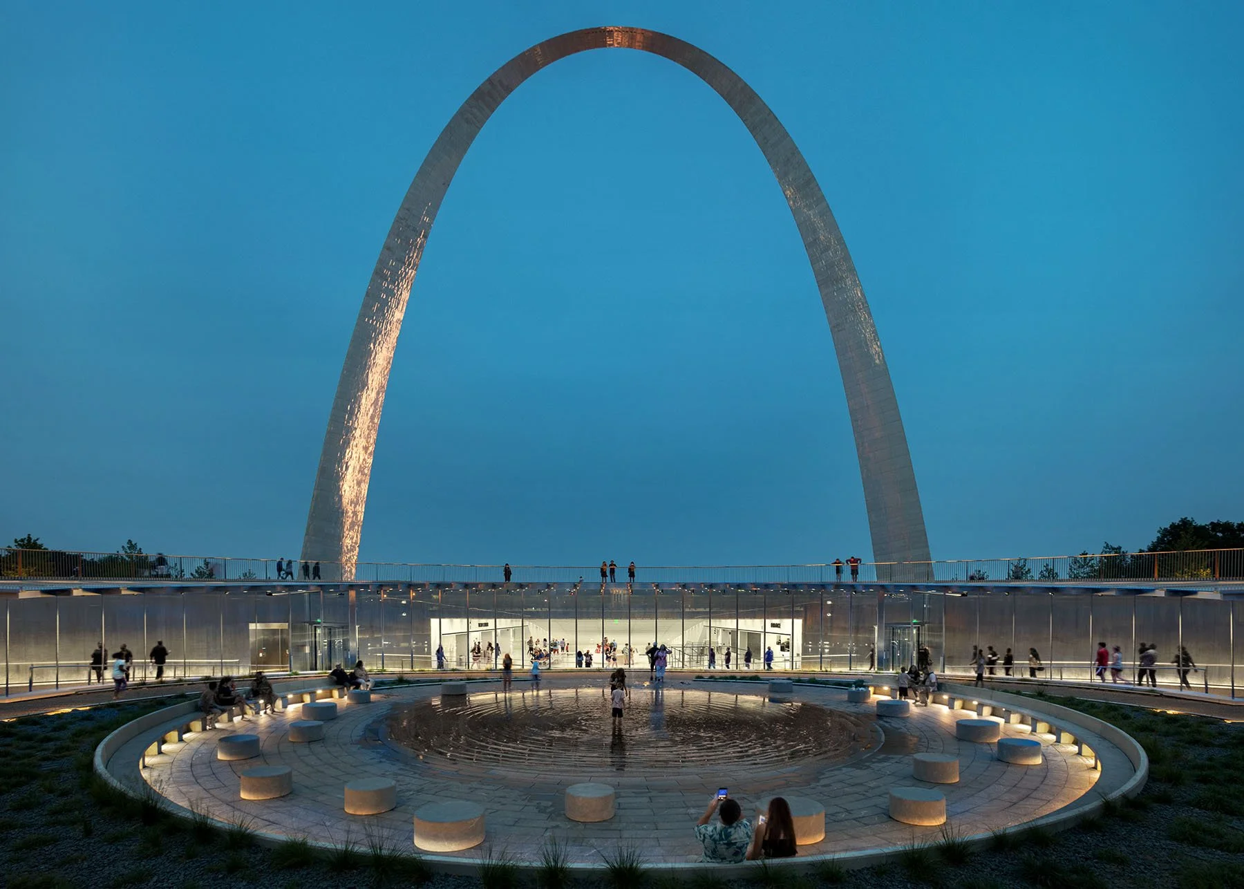 entry addition with arch in background at night, civic plaza in foreground