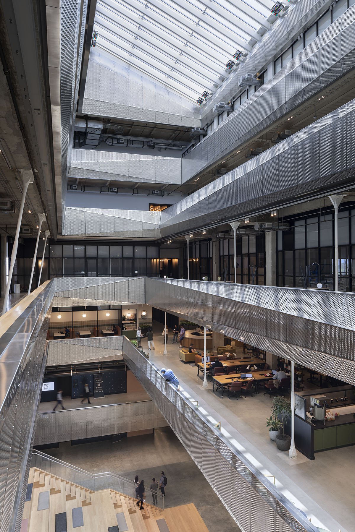 interior light well of the center of the building that shows communal work areas and skylight on the roof