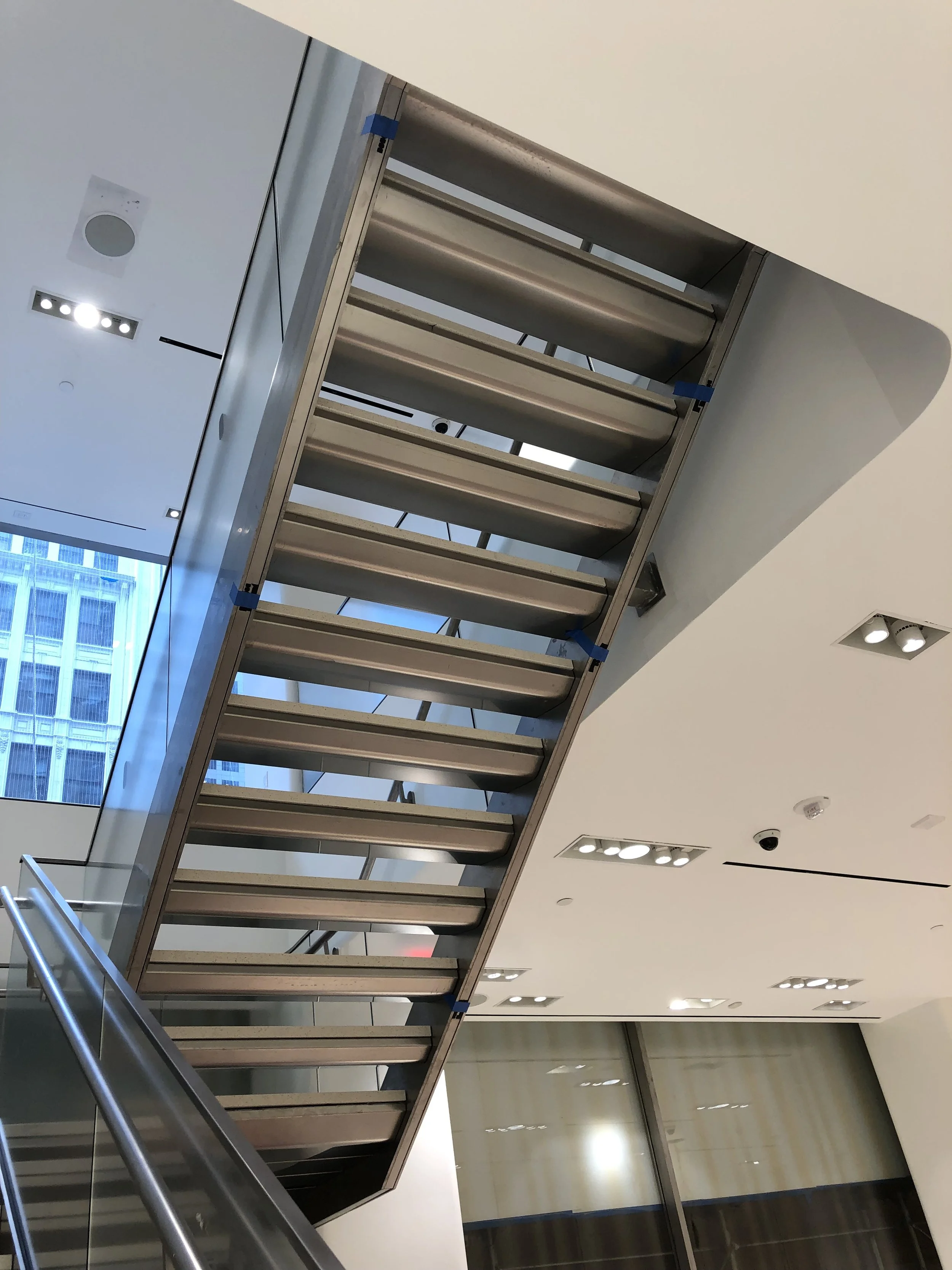 Interior architectural detail of a dramatic angular staircase inside the Nordstrom flagship store.