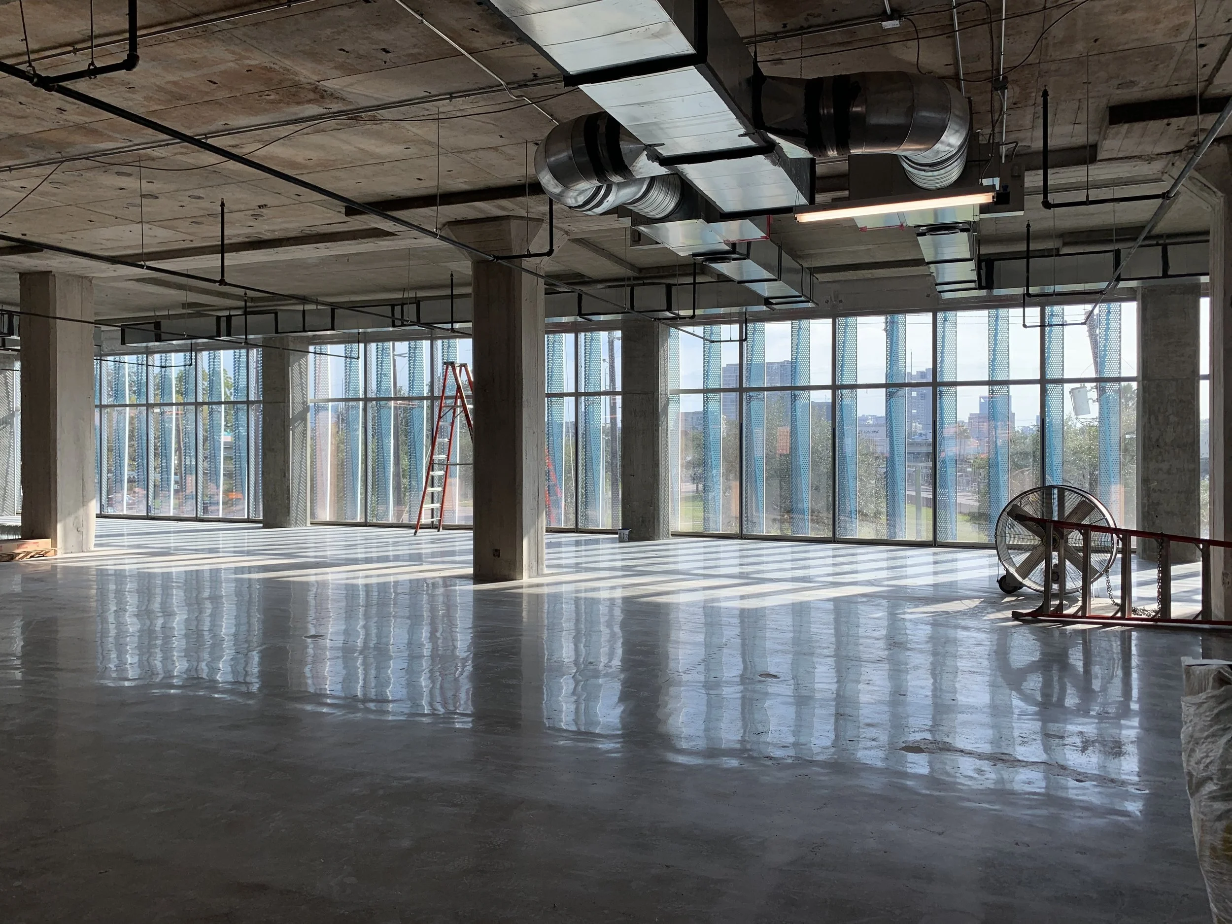 Raw interior space looking from inside out, sunscreens are blue as seen from indoors