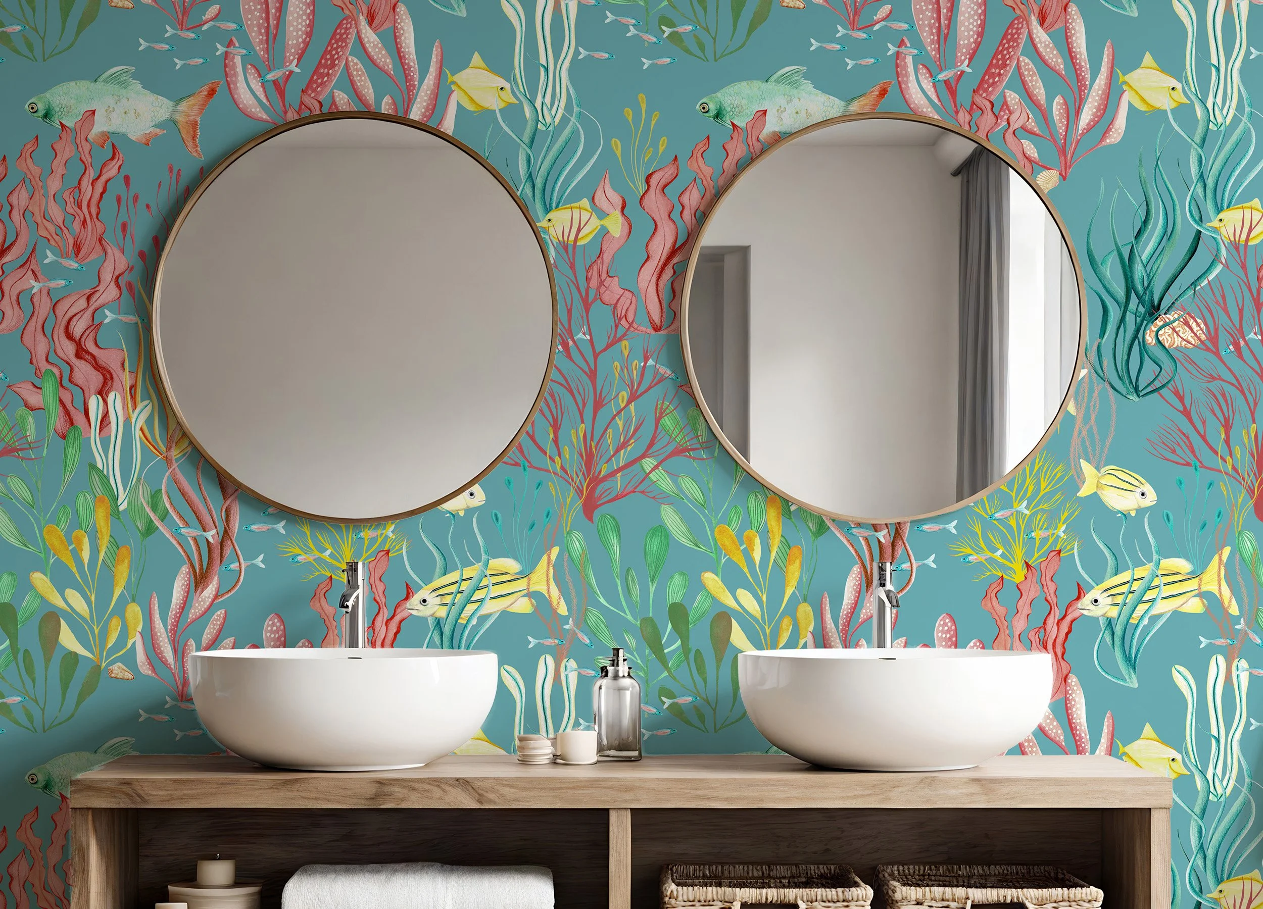 Coastal bathroom with underwater-themed wallpaper featuring fish and seaweed in aqua blue, coral, and yellow, paired with a floating oak vanity, dual white vessel sinks, and round brass-framed mirrors.