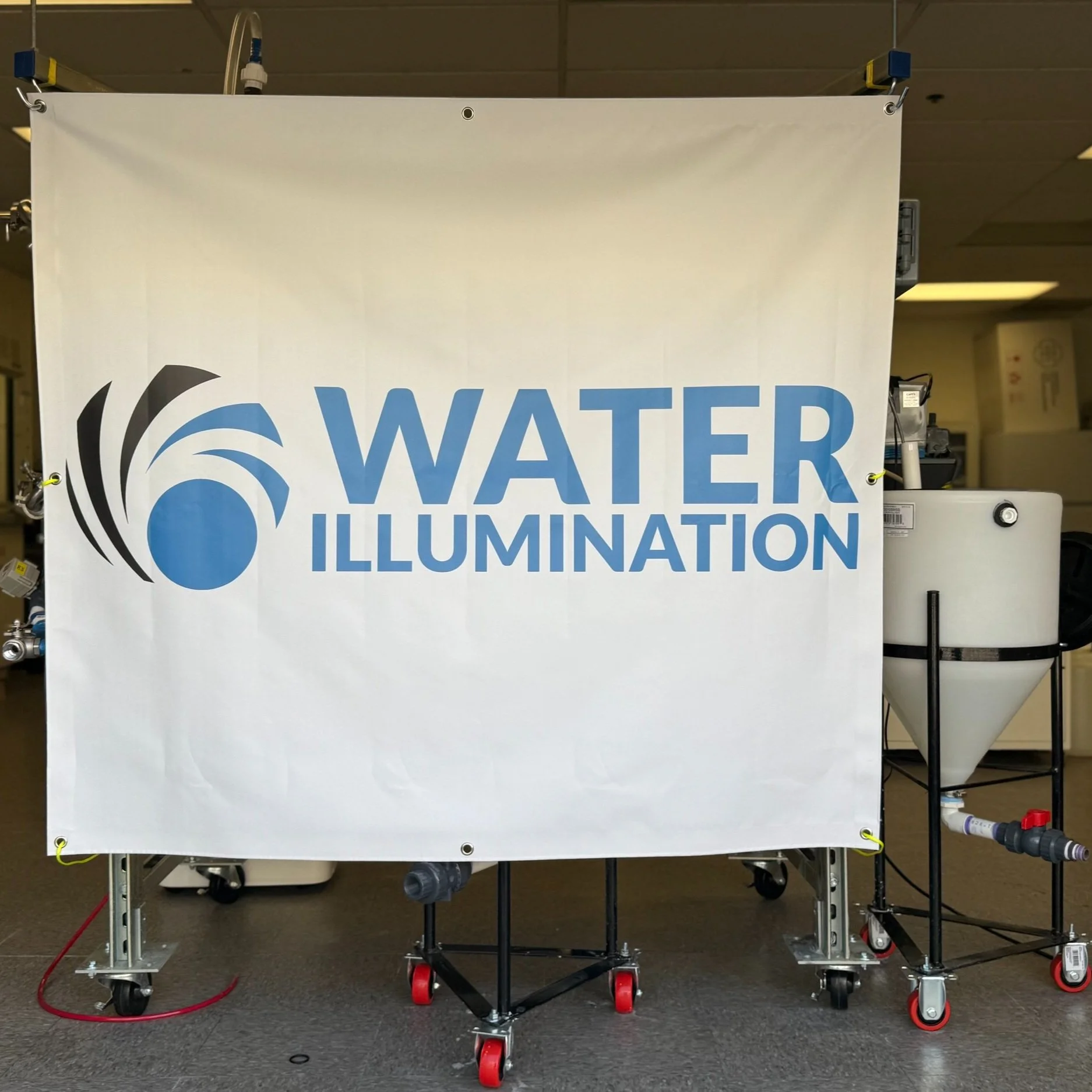 A large banner with the logo and text 'Water Illumination' on display, surrounded by equipment related to water illumination technology.