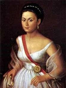 Portrait of a woman in 19th-century attire with a sash and flower brooch