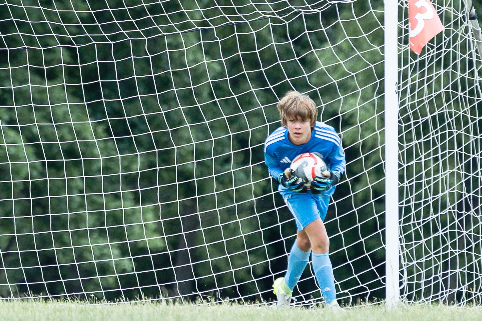 Youth soccer goalkeeper saving a goal. Action photography by Ania’s Little World Photography in the Chicago suburbs.