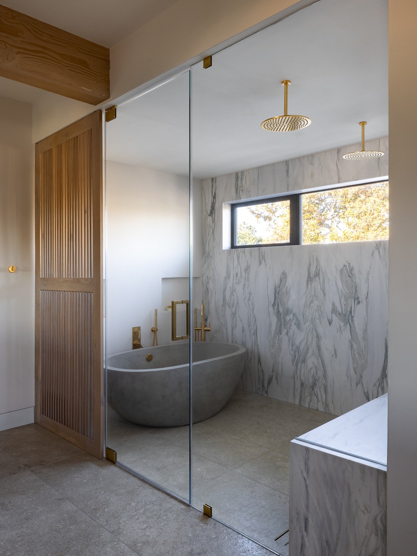 A spa-worthy escape in the 🤍 of the home!
This primary suite features dramatic marble, a sculptural tub, and warm brass accents&mdash;all grounded by clean lines and organic textures.