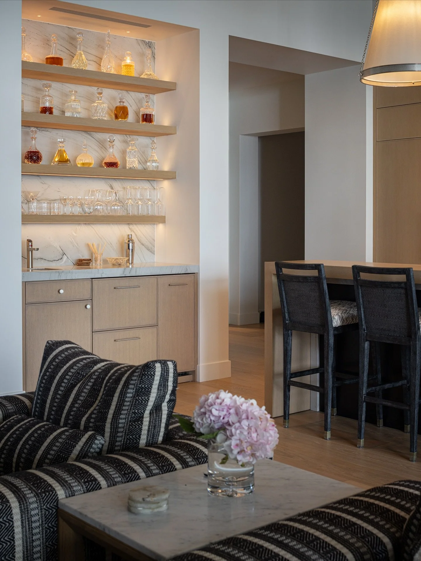 Stone that steals the show. This bar niche features continuous veining, warm oak shelving, and integrated lighting &mdash; a perfect example of how thoughtful materiality elevates a small moment.
Photo: @naderessaphoto 
Builder: @clintthomson 
#tense
