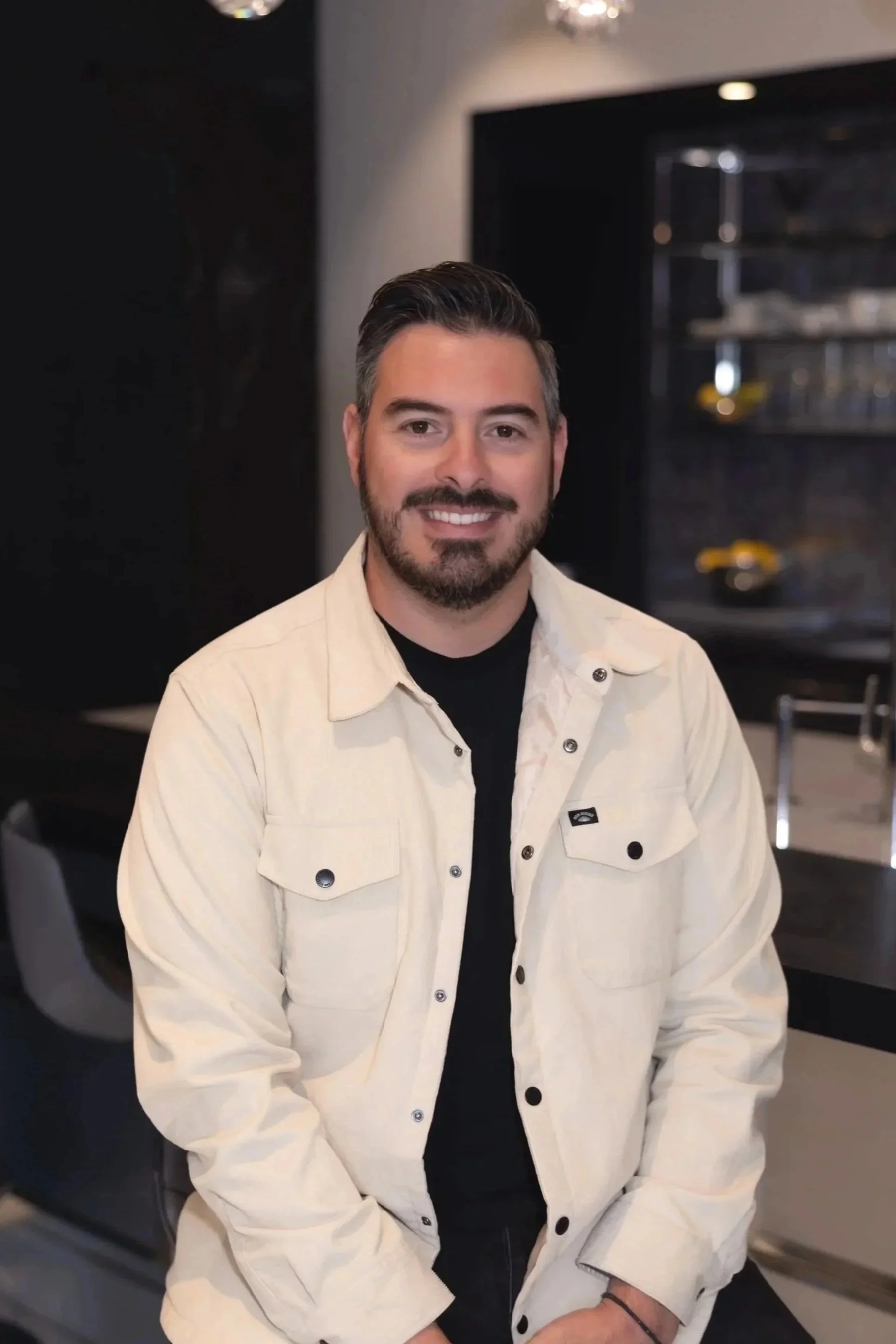 Several mosaic tile samples in various colors including beige, pink, black, green, and gray, displayed on white boards with a green leafy plant nearby.