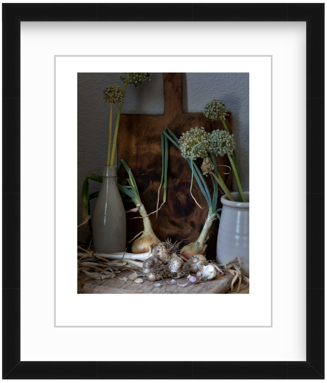 Moody still life photograph of onions and garlic arranged in soft, painterly lighting