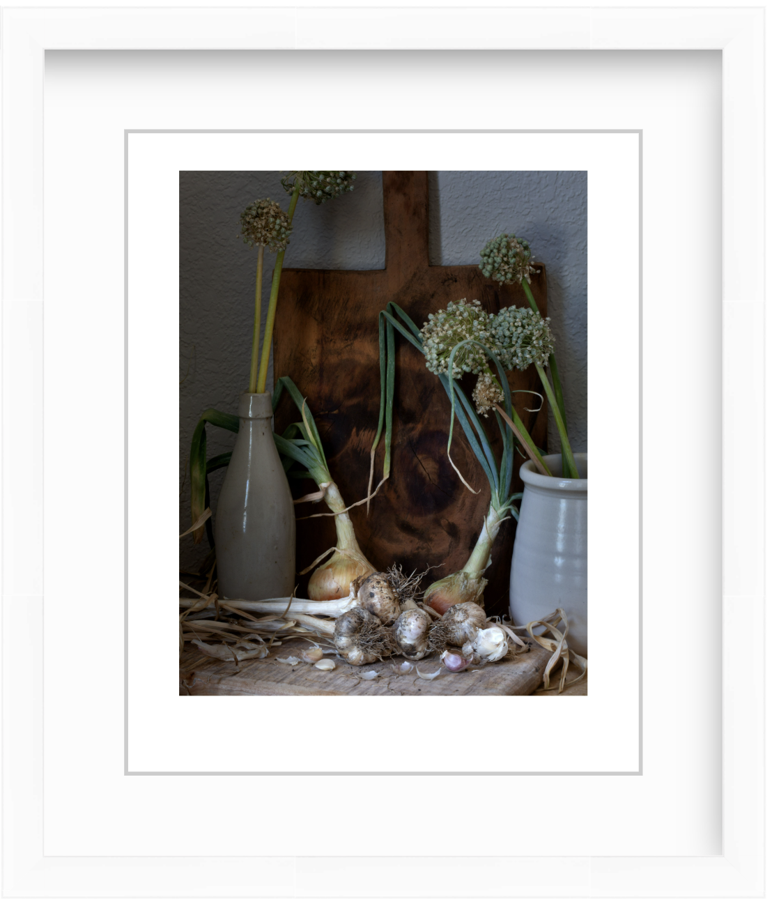 Moody still life photograph of onions and garlic arranged in soft, painterly lighting