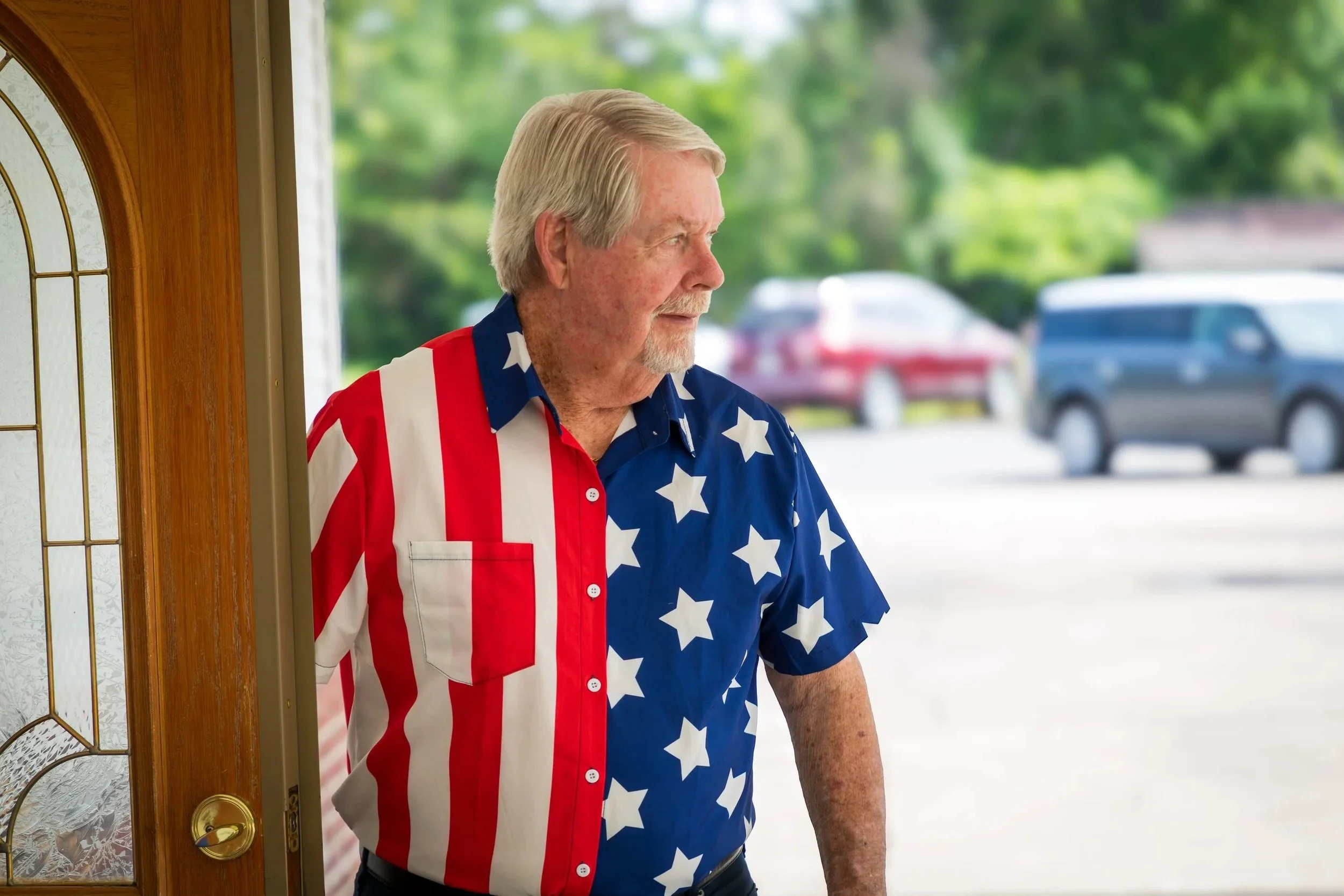 Purple hyacinth flowers next to a white wood sign with "Welcome" written on it, placed on a gray surface.