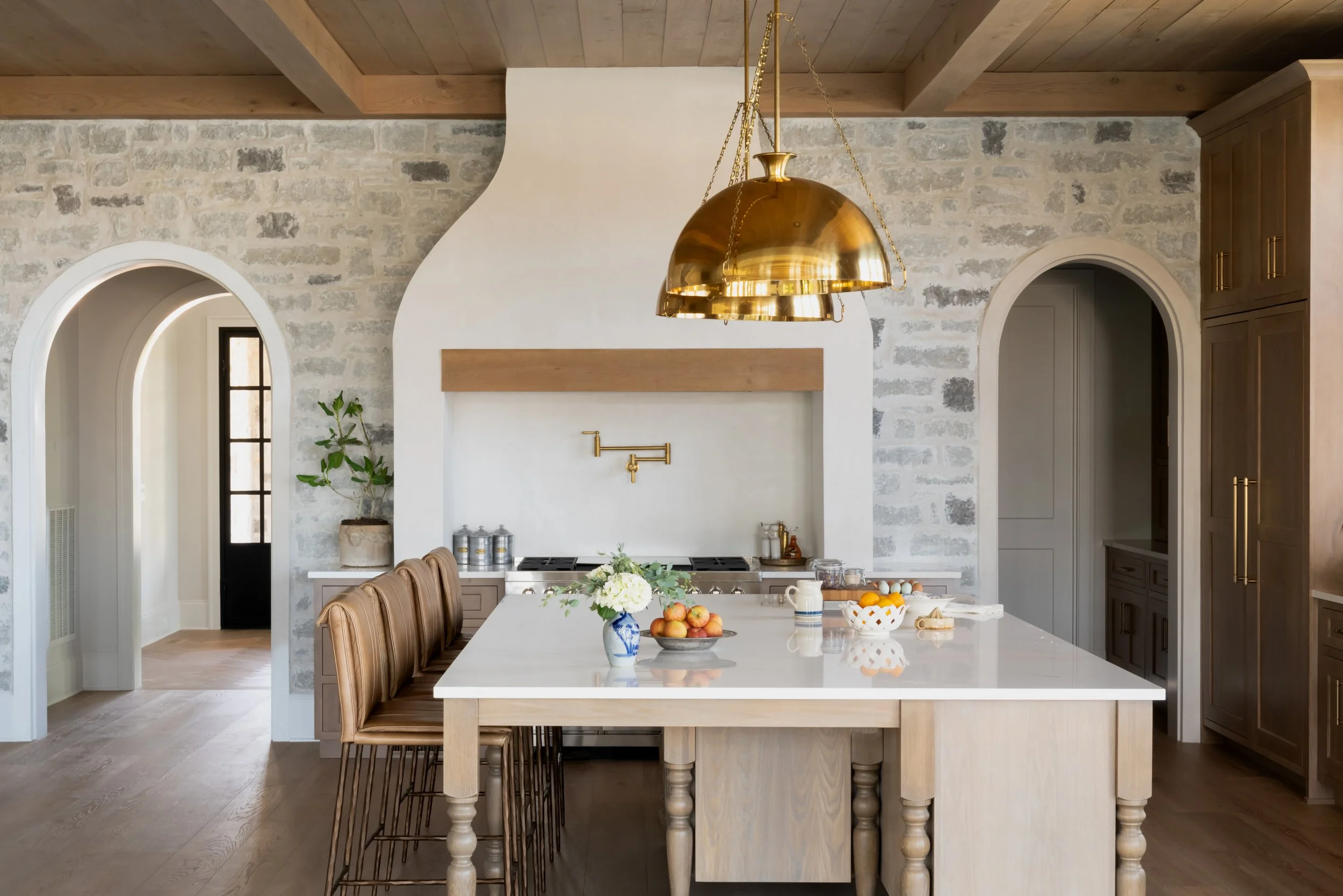 A beautiful kitchen island with gold chandelier above