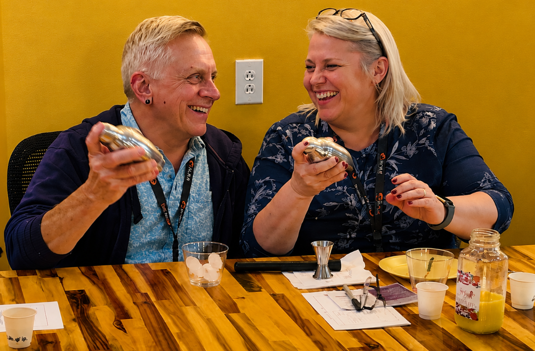 People with cocktail shakers laughing