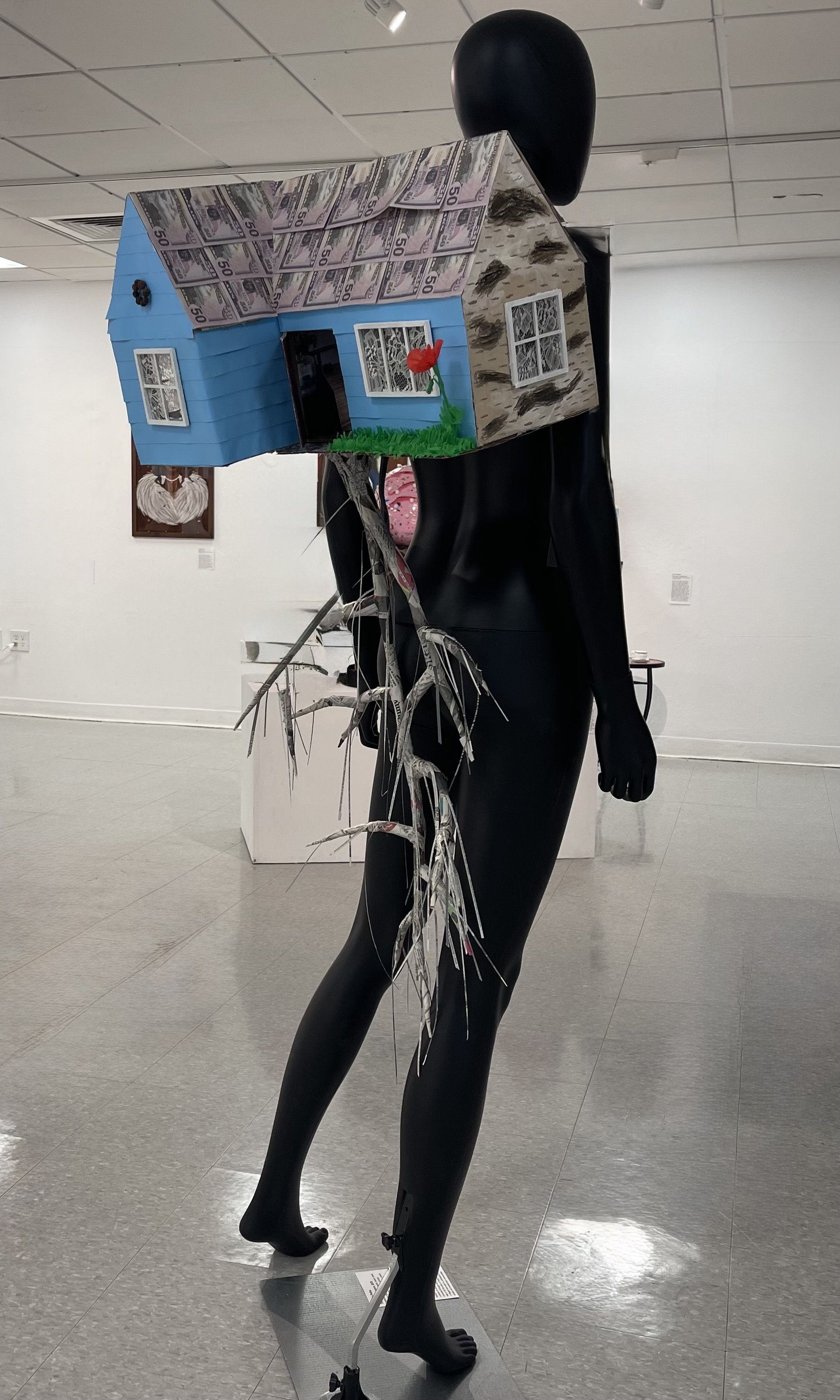 The Polish Diaspora, 2025. Mixed Media including cardboard boxes, newspaper, paper towel, backpack straps, found fabric scraps, collage elements of printed images, prank money, acrylic paint, crepe paper. 41 x 18.5 x 12.25 inches. 