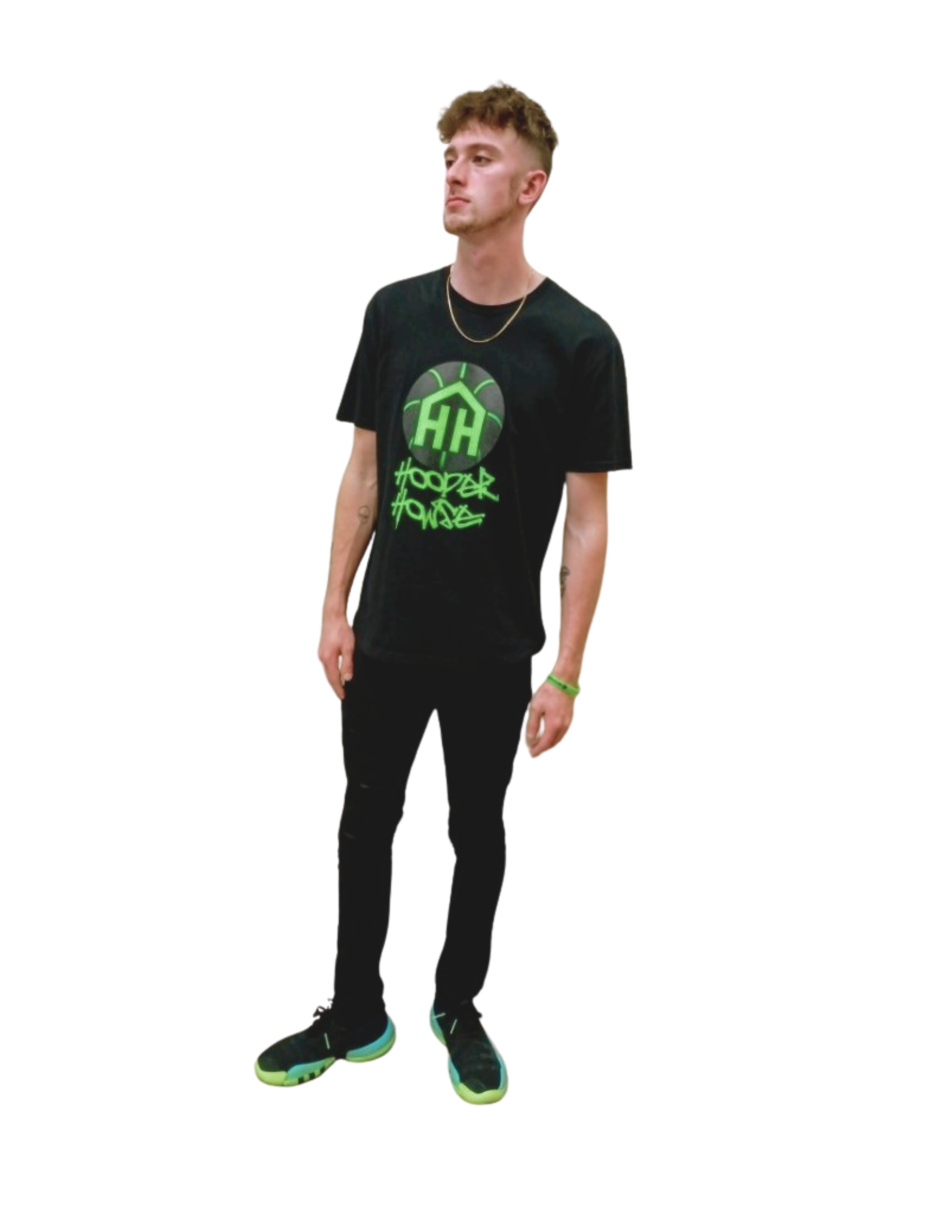Young man with short, wavy brown hair, wearing a black graphic t-shirt with green design and text, black pants, and black sneakers with neon accents, standing against a black background.