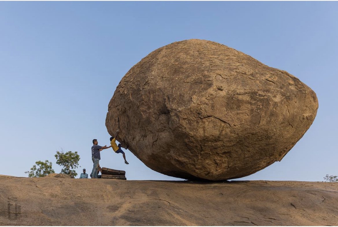 Manikandan Kumar bouldering against an open blue sky