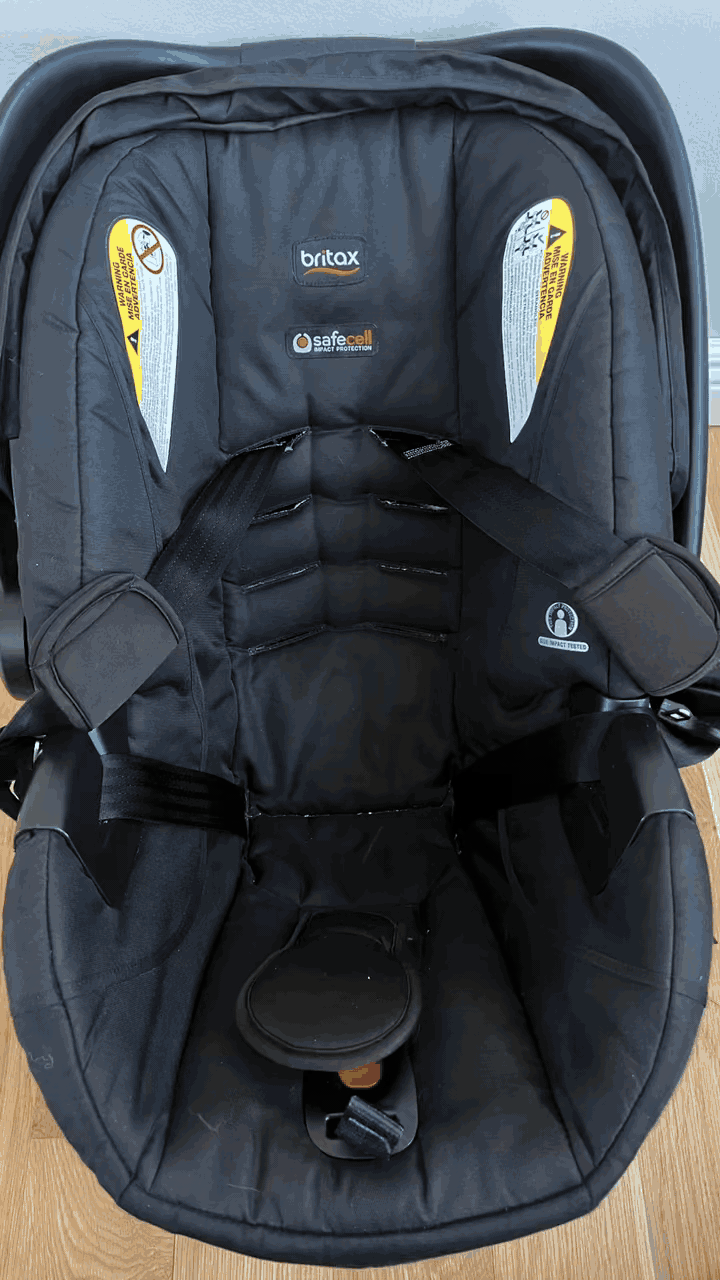 Black Britax child car seat with safety labels and harness straps
