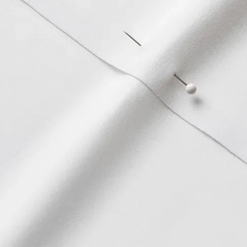 Close-up of white fabric with a pin and a pinhead holding the fabric in place.