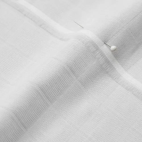 Close-up of white fabric with a pin and a pinhead holding the fabric in place.