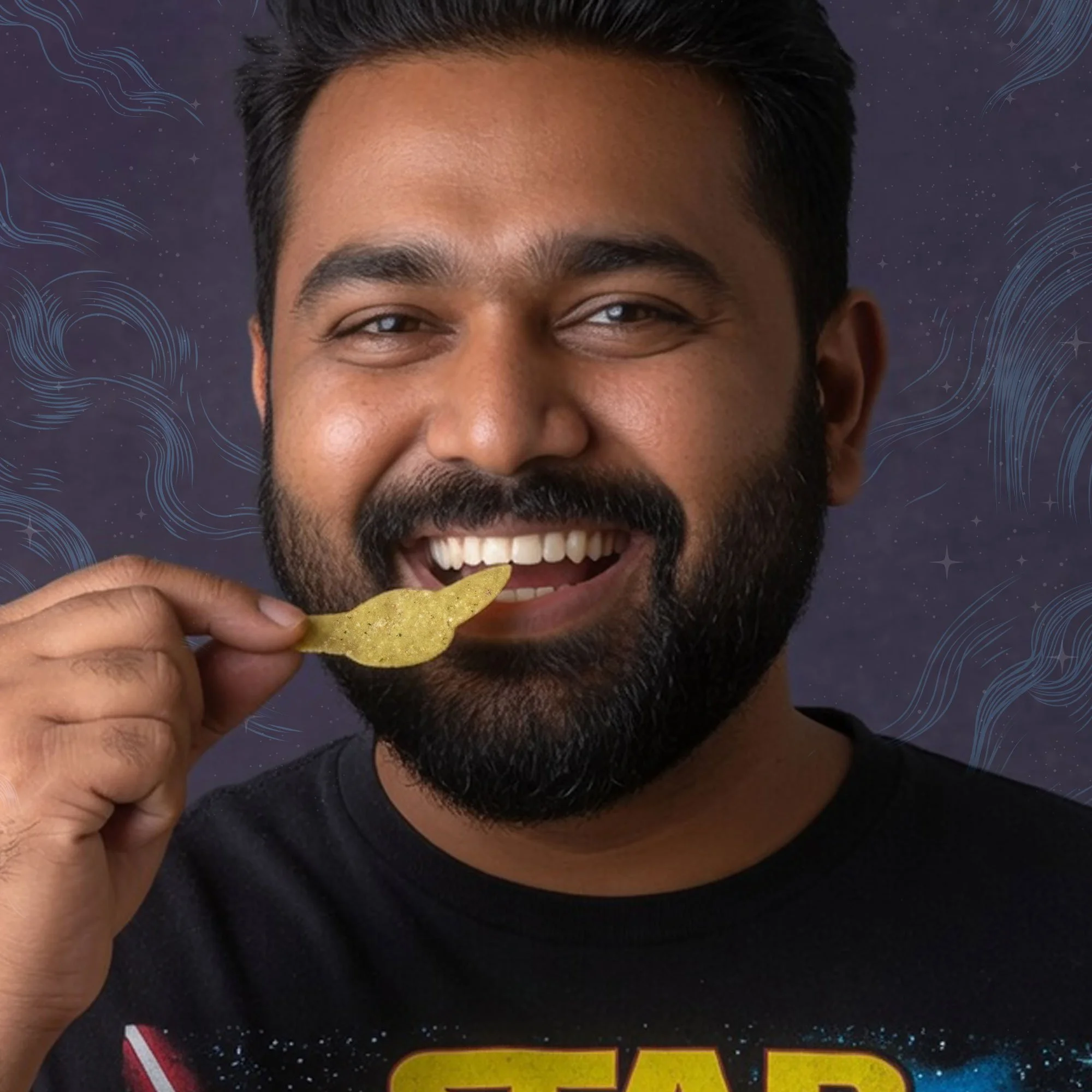 A smiling man with dark hair and facial hair holding a yellow potato chip near his mouth.