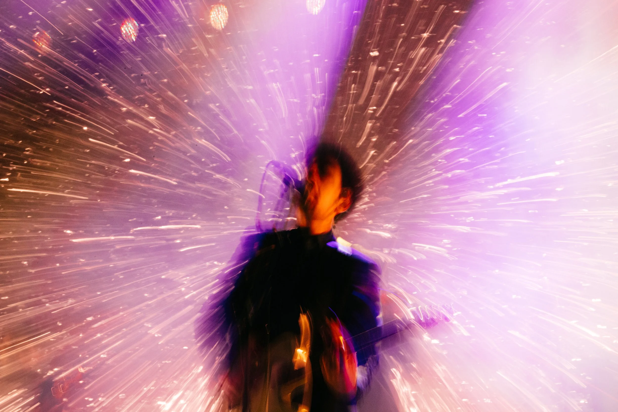 Pessoa em movimento com efeitos de luz e cores vibrantes ao redor
